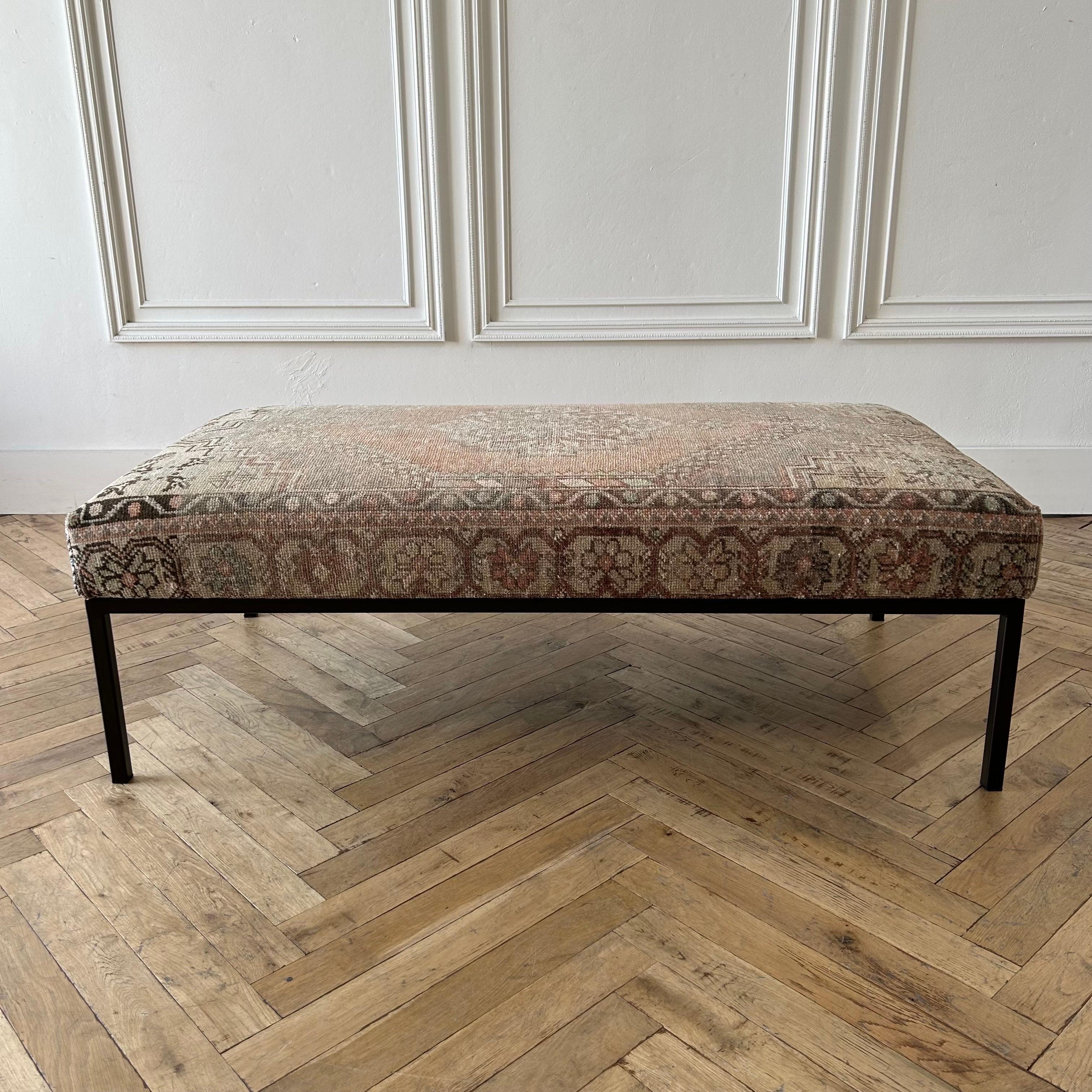 Custom made bench ottoman by Bloom Home Inc.

Size: 54”W x 28”D x 18”H

Custom made metal base, and powder coated in a dark iron bronze finish.
The upholstered top is from an antique or vintage turkish rug.

Color: brown / gray / natural /