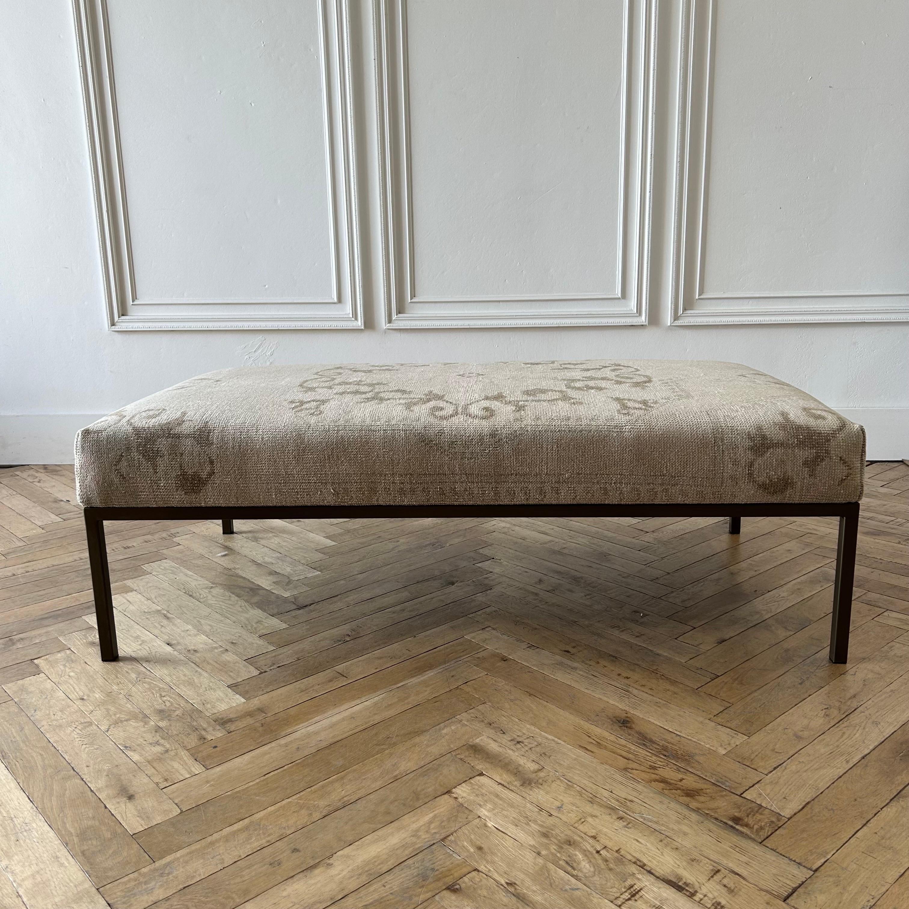 Custom made bench ottoman by Bloom Home Inc.
Size: 56”w x 32”d x 18”h
Custom made metal base, and powder coated in a dark iron bronze finish.
The upholstered top is from an antique or vintage turkish rug.
Color: brown / coco / white / faded pink