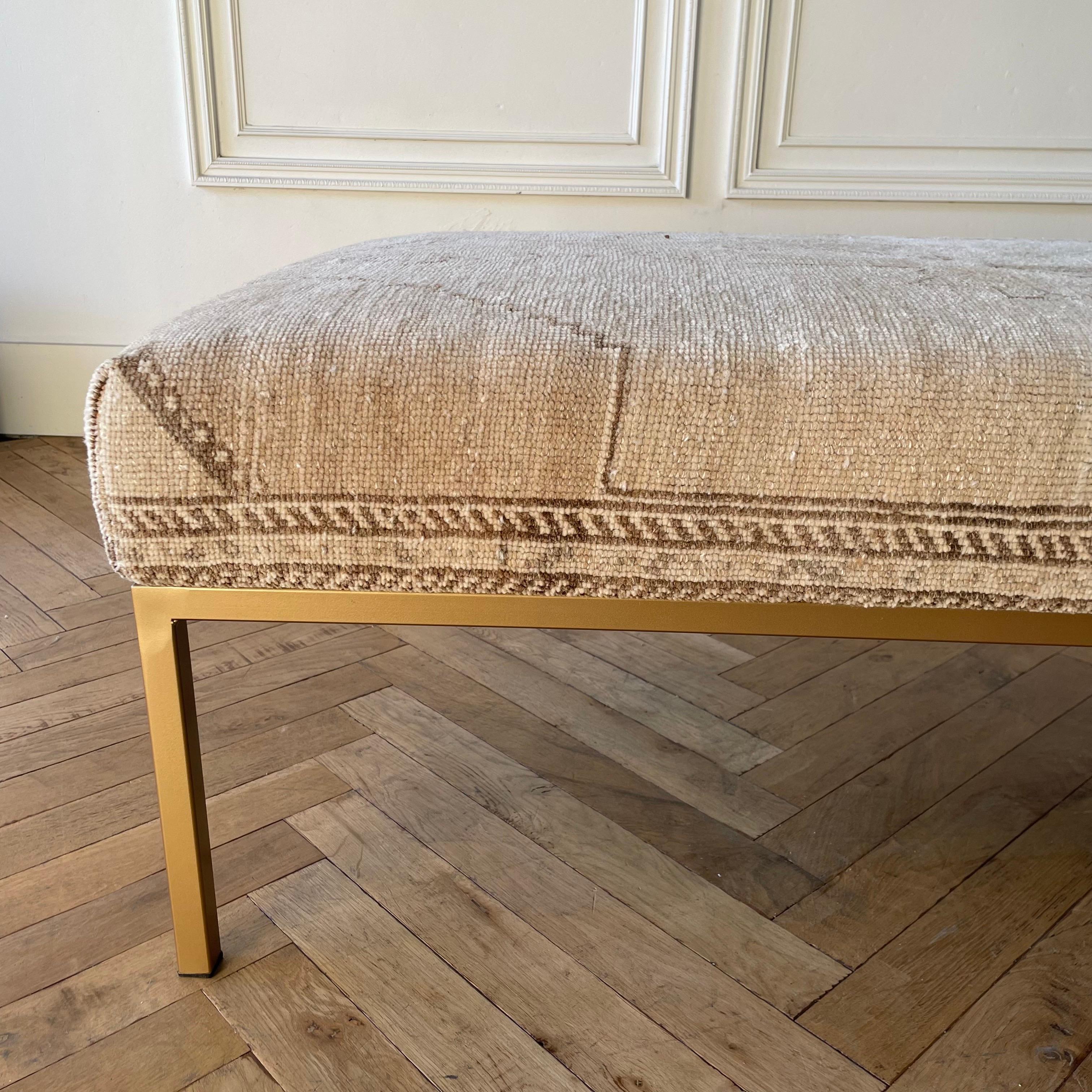Custom made Turkish wool rug ottoman with metal legs. Measures: 65” x 31” x 18”.