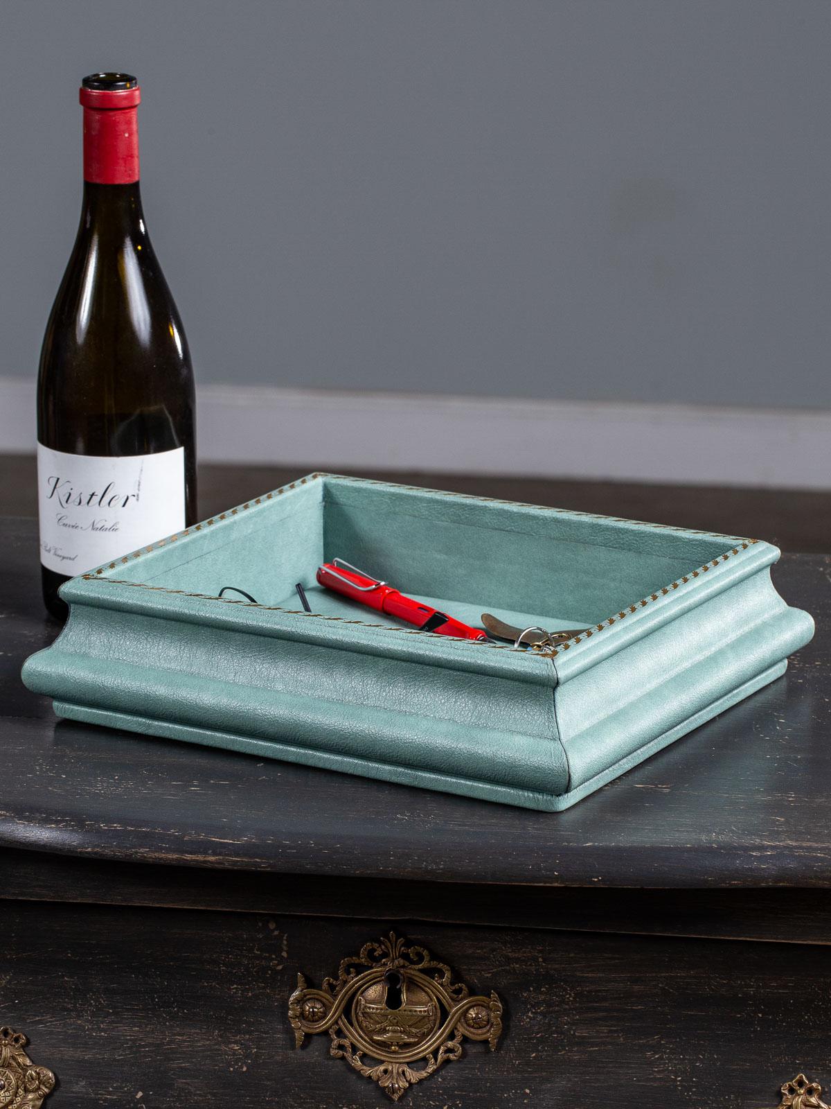 A sexy custom turquoise leather tray with raised sides known as a 
