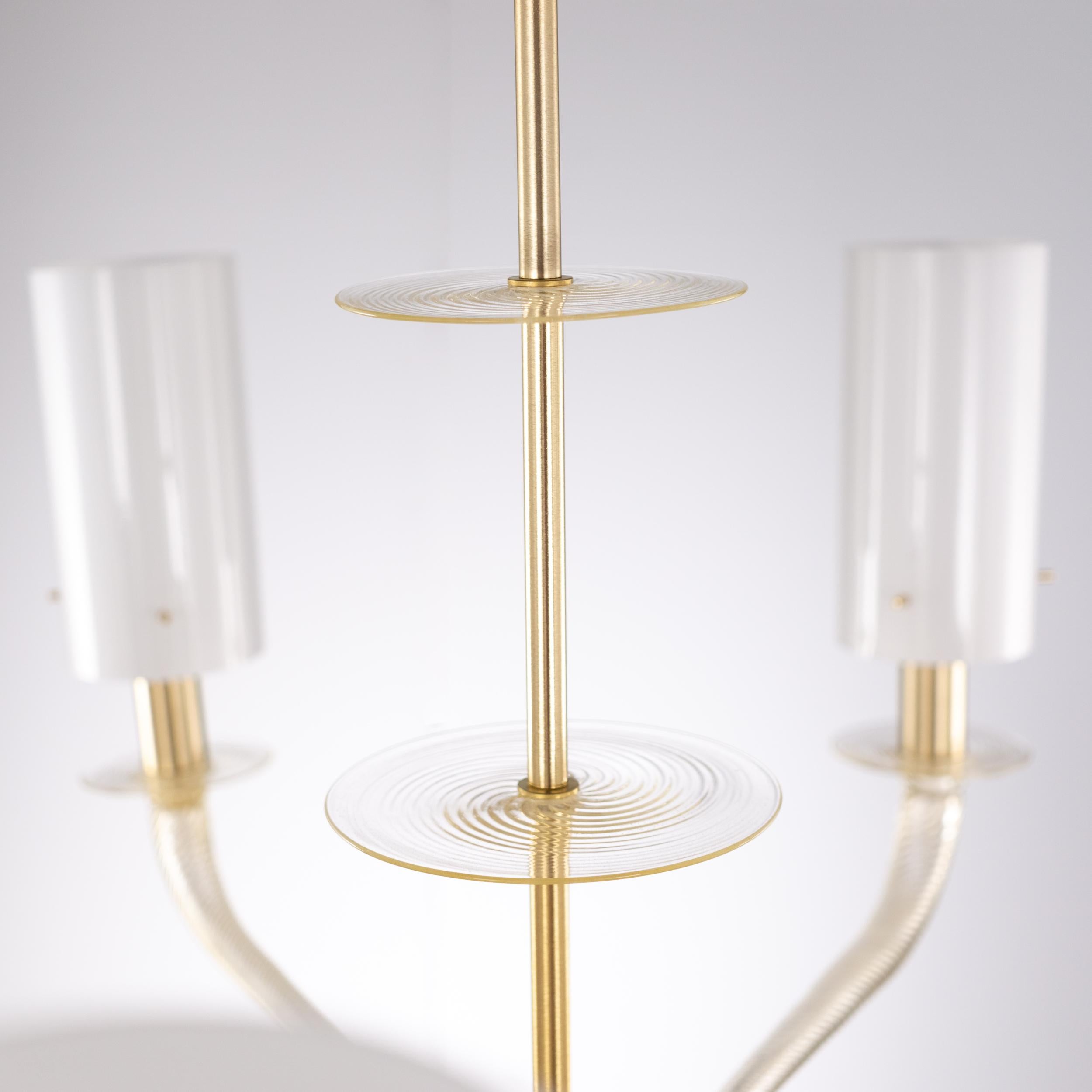 Lampadario veneziano Tribeca, 7 bracci, vetro di Murano bianco, montatura dorata di Multiforme.
Tribeca è un lampadario di design in vetro di Murano totalmente reinventato rispetto ai lampadari classici veneziani, progettato utilizzando nuove