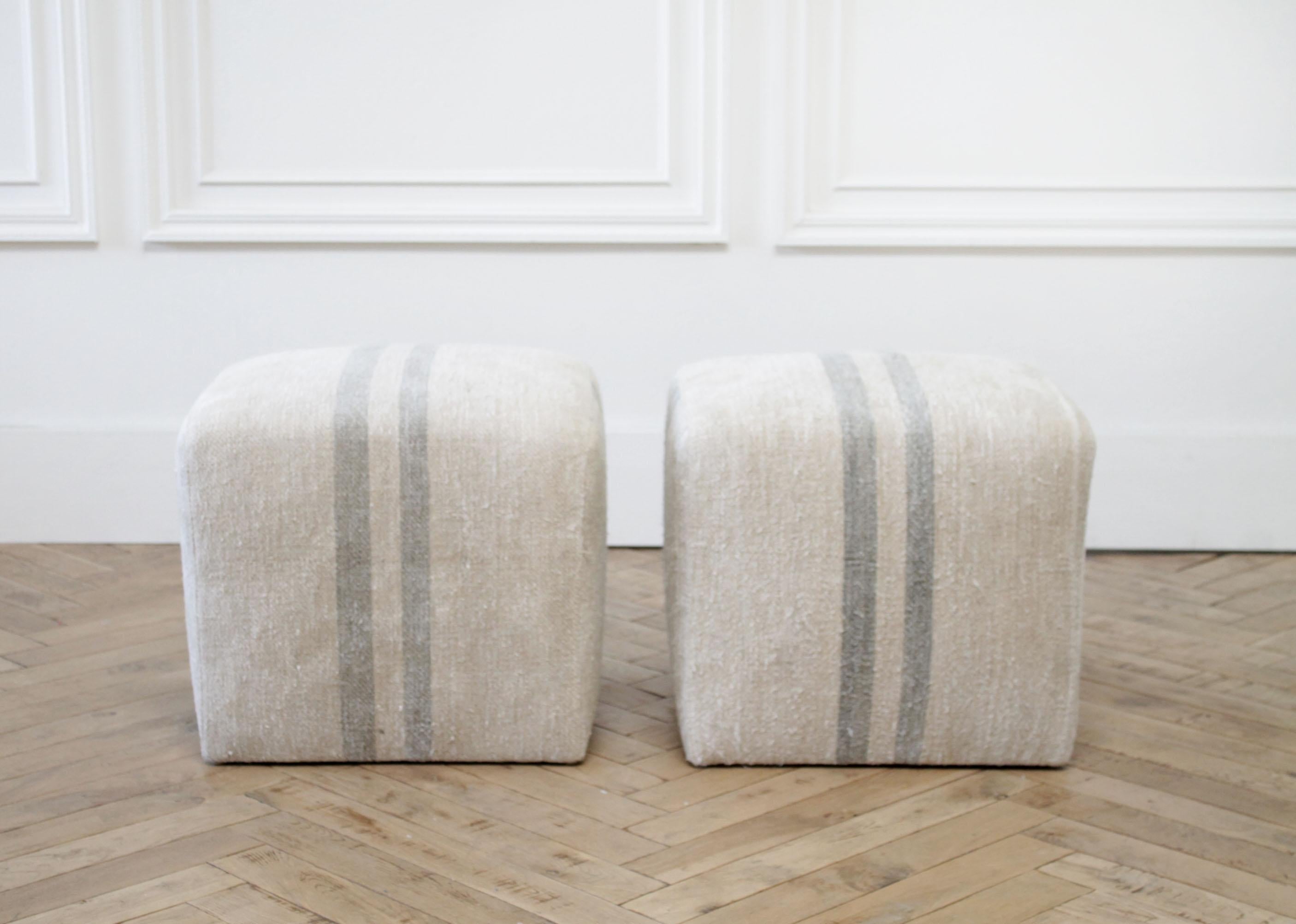 Custom made vintage grain sack cube ottomans.
Made from vintage textiles, this has an oatmeal linen color background with soft blue gray stripe. A soft nubby texture, these are perfect for in front of the fireplace, or putting your feet up next to