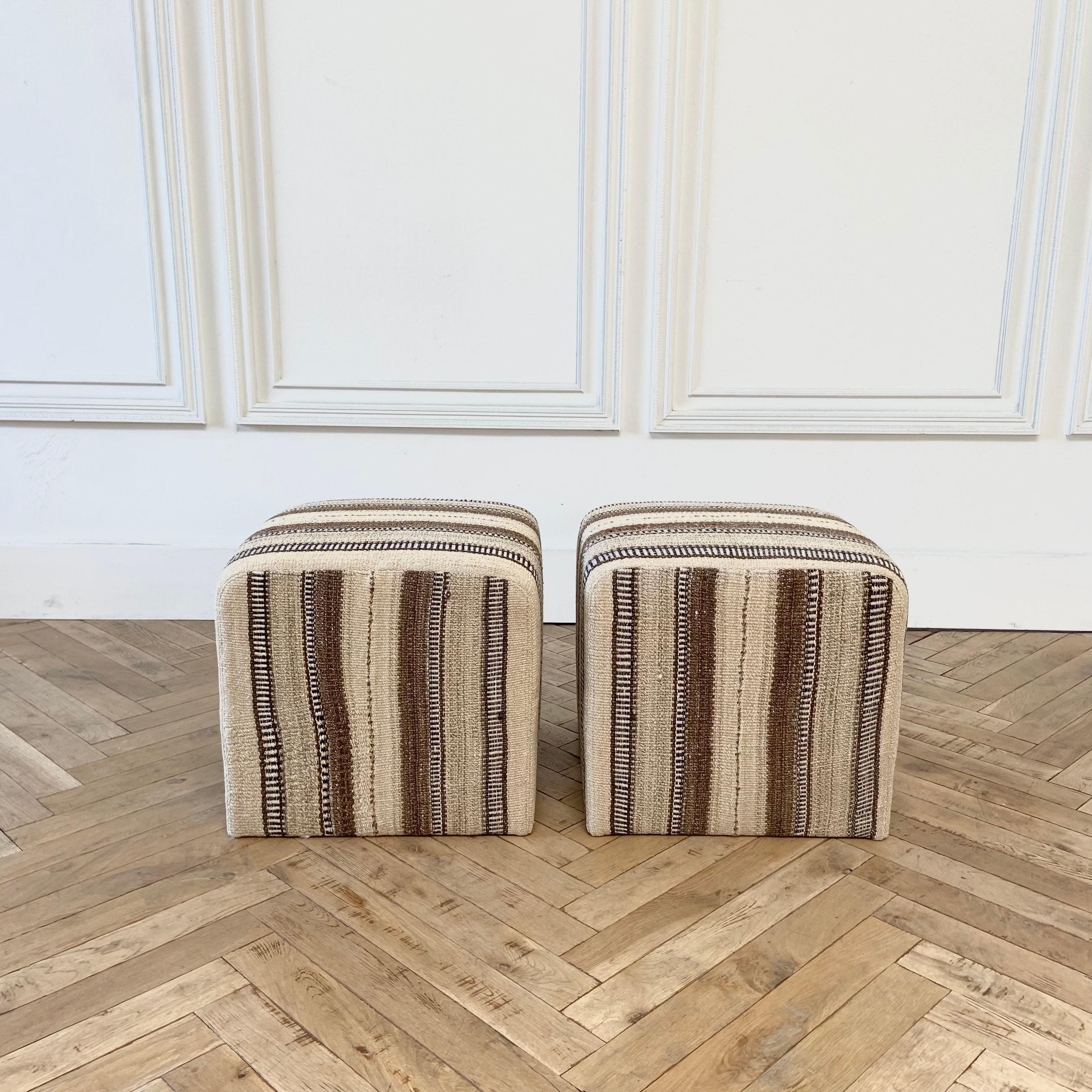 Vintage rug cube ottoman in warm brown tones by Bloom Home Inc.
This particular one has a wonderful neutral brown stripe with light and dark and contrasting creamy color. We have an additional ottoman that coordinates well with this one in the same