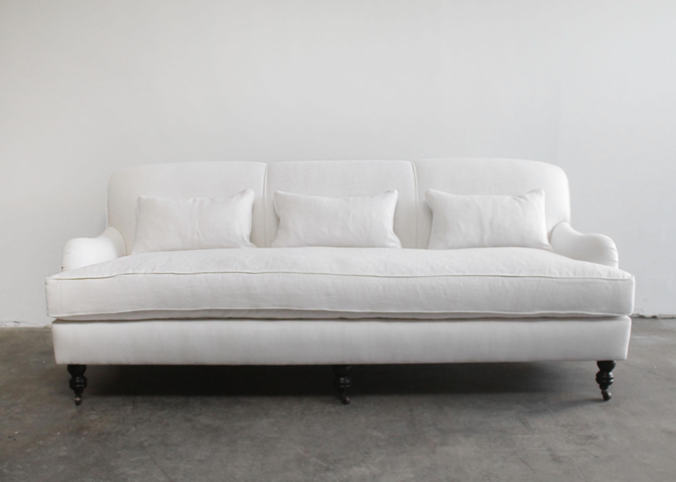 White linen English arm rolled back sofa with casters.
Custom made to order, upholstered in a heavy weight Belgian linen, with down feather seats.
Very comfortable to sit in, with a medium density foam core seat, wrapped with a 90/10 down feather