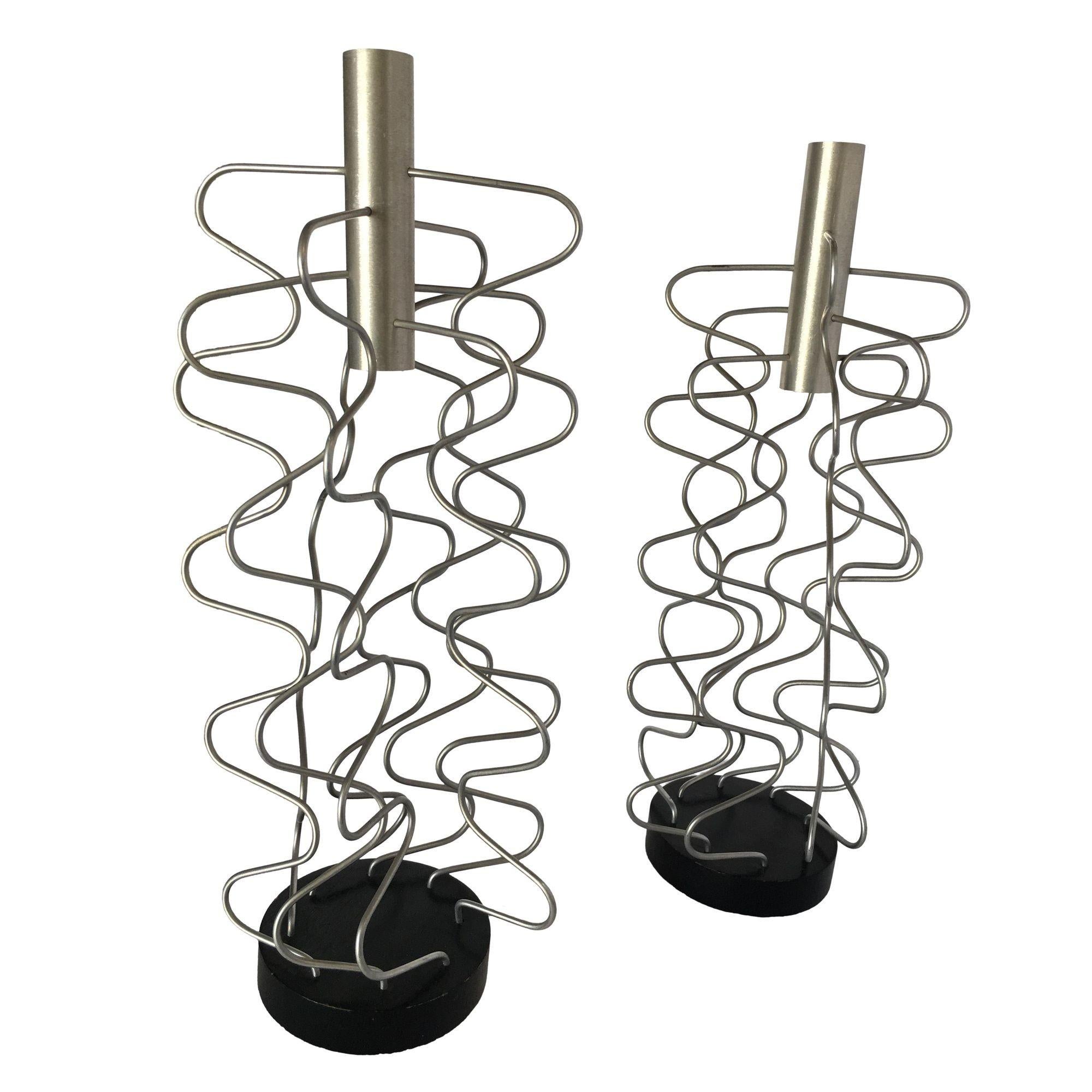 Pair of custom Made Wire Art candlestick holders made of 8 sculptural wire pieces fixed to a black base with chrome holder along the top.