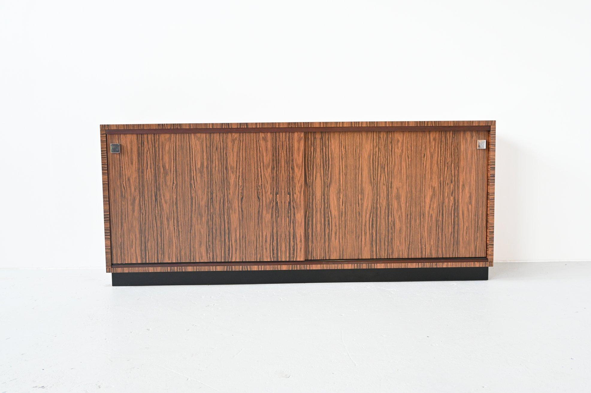 Beautiful sideboard custom made by Belform, Belgium 1960. This very nice cabinet is made of high quality veneered zebrano wood with a very nice grain. It has two large sliding doors with shelves behind and a black lacquered wooden frame. Typical