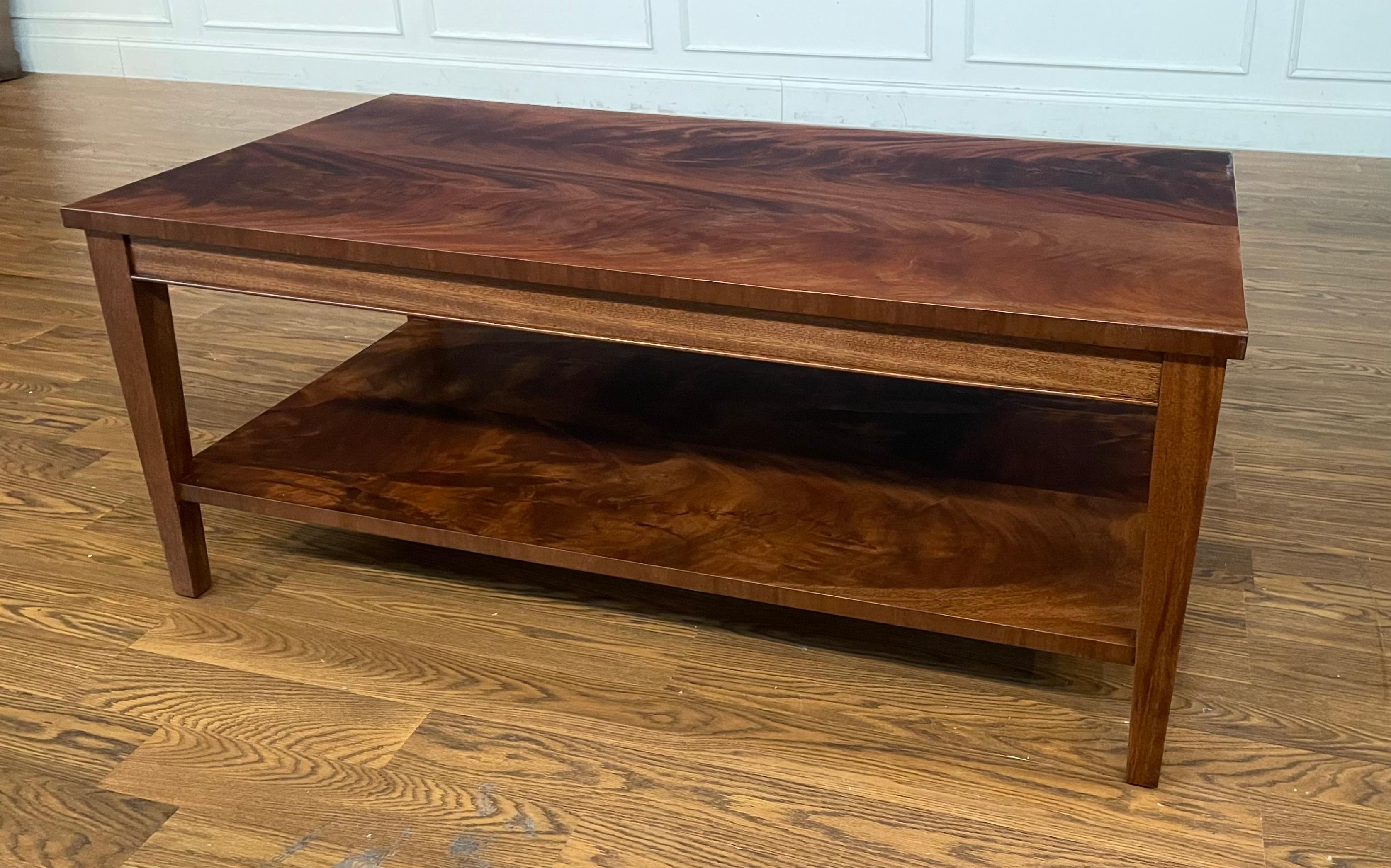 This is a rectangular mahogany cocktail table made-to-order in the Leighton Hall shop in Suwanee, Georgia.  It features a top and lower shelf of reverse-slip-matched swirly crotch mahogany, square tapered legs, and a medium brown mahogany color with