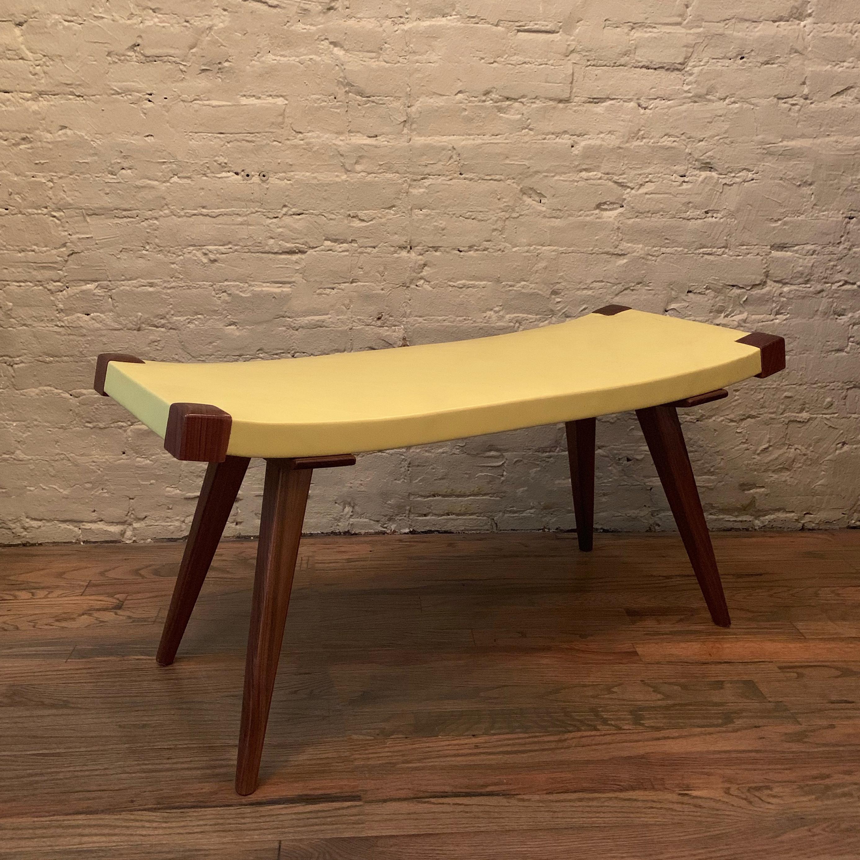 Custom, Mid-Century Modern style bench features walnut and ash tapered legs with a gently sloping, yellow leather seat, made in Brooklyn, NY by City Foundry.