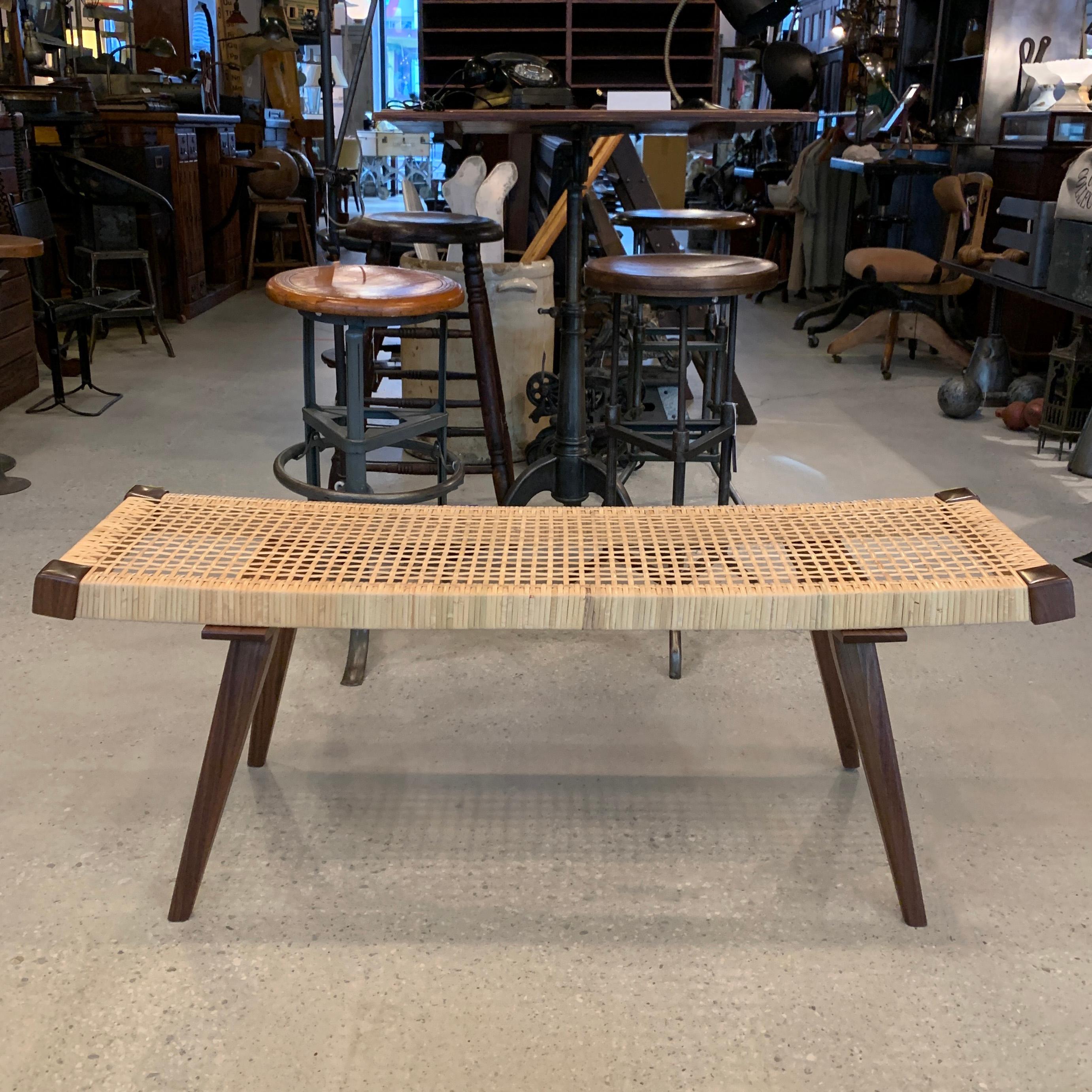 CF signature, Mid-Century Modern style, bench features a solid walnut and ashwood frame with handwoven rattan seat, custom made in Brooklyn by cityFoundry. The bench slopes from 18 - 17 inches in the center.