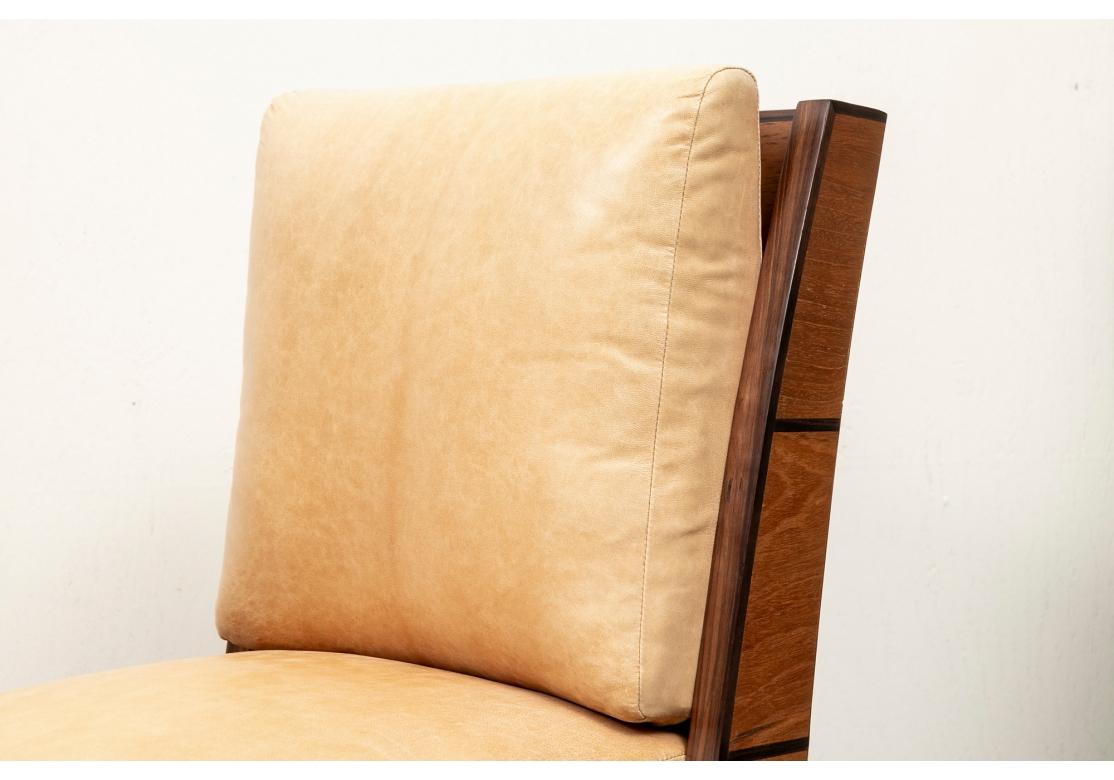 Ein stilvolles Paar  Slipper Chairs mit hellbraunen Lederkissen und schönen Exotenholzrahmen. Die Stühle haben eine minimalistische Form mit einer nach oben gebogenen Rückenlehne und sich verjüngenden Beinen mit Fußkappe und Beinakzenten aus