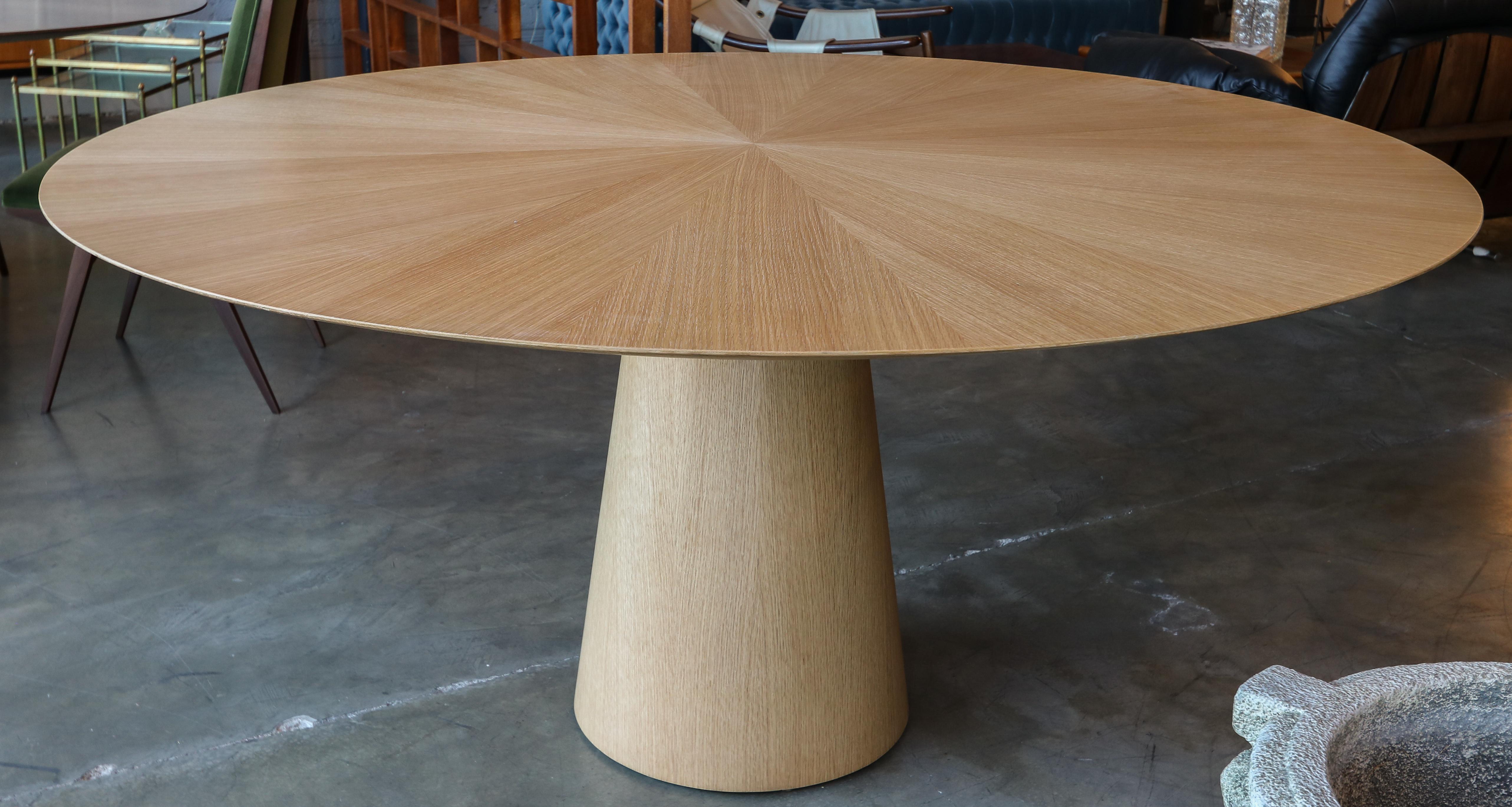 Custom round dining table with pedestal leg made in American oak.  Made in Los Angeles by Adesso Imports.

Can be done in different woods, finishes and sizes.
