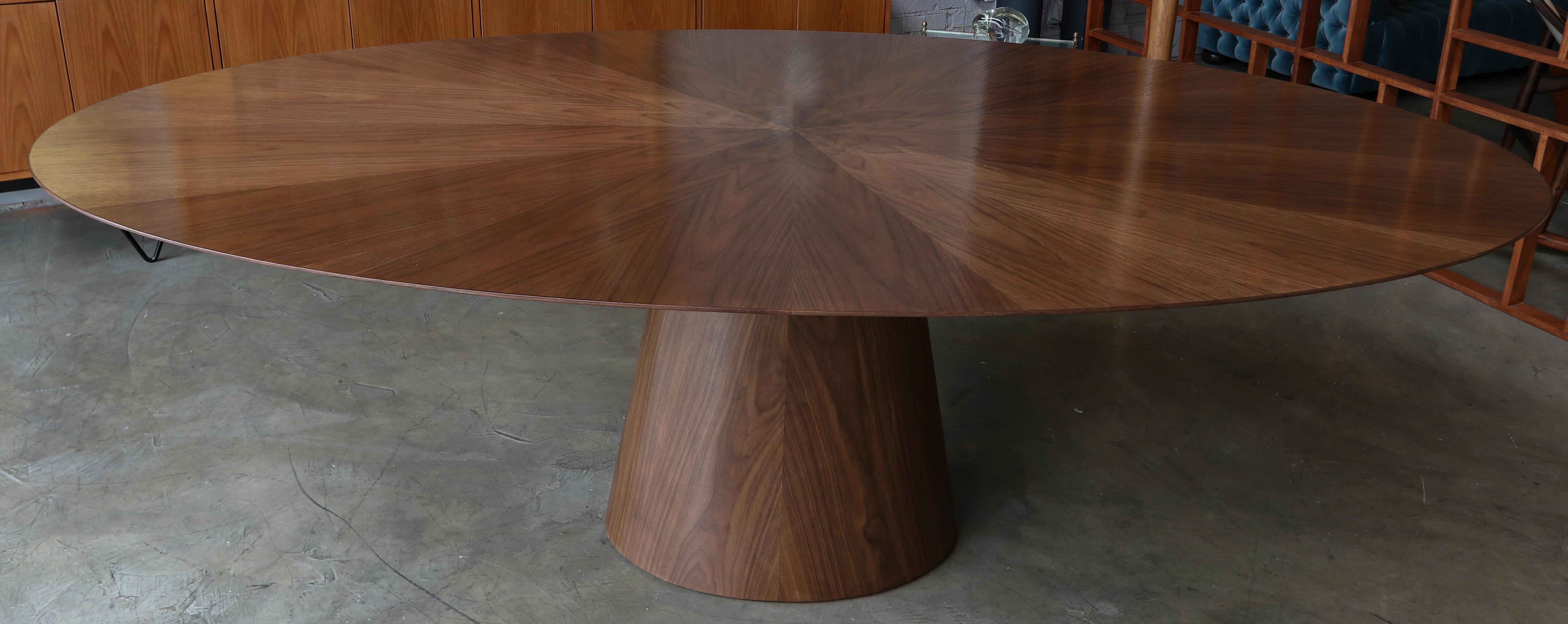 Custom oval dining table with pedestal leg made in American walnut with flower detail in center of top.  Made in Los Angeles by Adesso Imports.

Can be done in different woods, finishes and sizes.