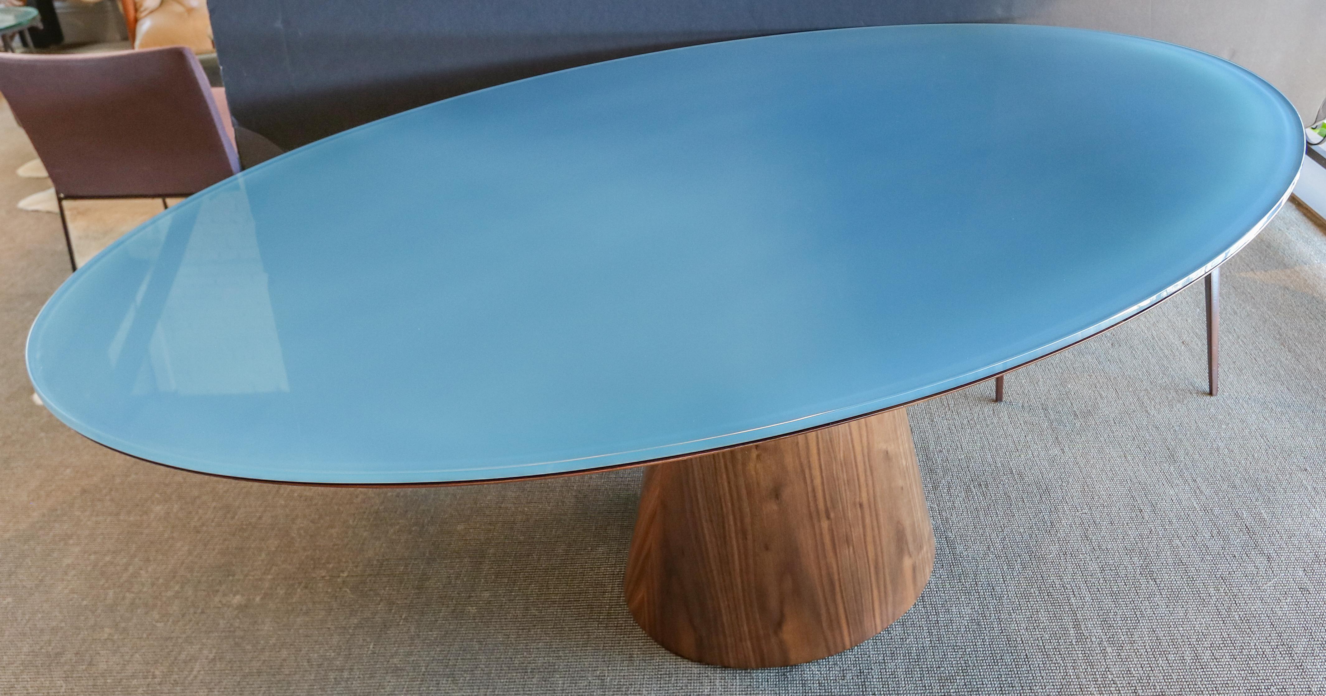 Custom oval dining table with pedestal leg made in American walnut with blue reverse painted glass top.  Made in Los Angeles by Adesso Imports.

Can be done in different woods, finishes and sizes.