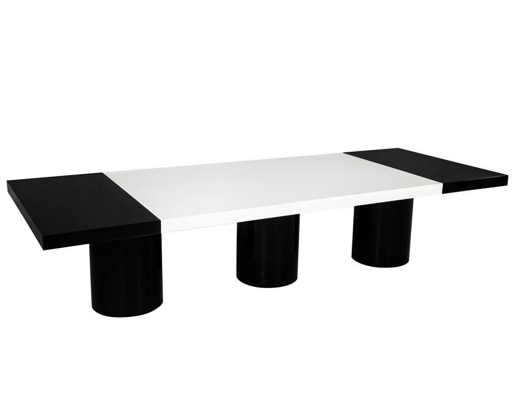 Custom modern black and white dining table by Carrocel. Beautifully designed with a polished white lacquer center with hand polished black columns and ends. Table extends with 1 leaf for each end.

Due to the size and weight of this item we are only