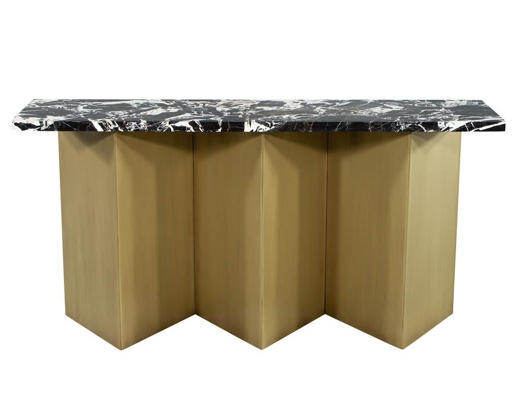 Custom modern brass and marble console table. Featuring imported Italian marble top with unique intricate black and white veining. Completed with a custom designed zig-zag shaped brass platform. The perfect addition for an entrance or hallway. Price