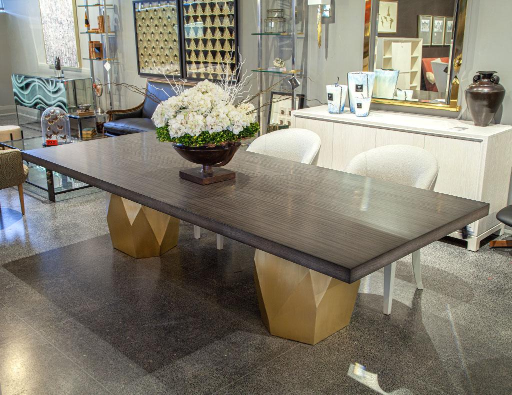 Custom Modern grey dining table with metal geometric pedestals. Carrocel Custom design, hand crafted in Toronto, Canada. Composed of walnut, finished with a rich 2 tone grey satin lacquer with a pair of brass patinated geometric pedestals. Can be