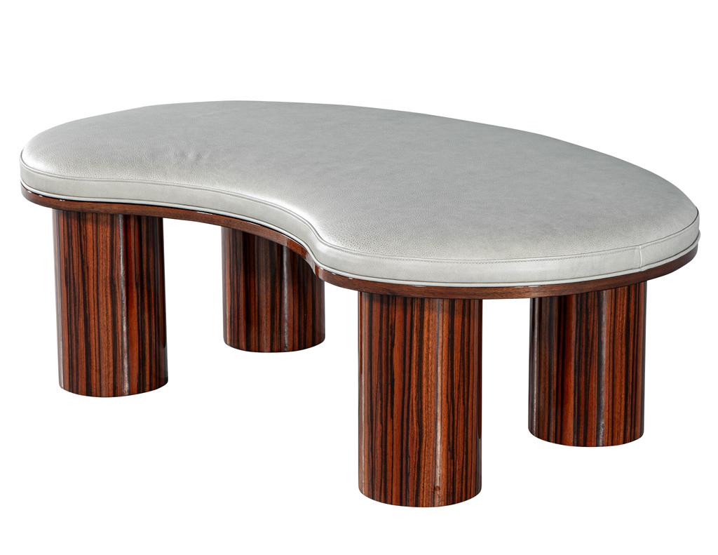 Elevate your décor with this exquisite, newly handcrafted Carrocel custom bench. Featuring a distinctive kidney shape, this piece blends modern styling with elegant Art Deco influences. The beautiful column legs and edge trim are crafted from
