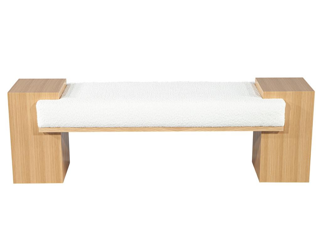 Bringen Sie einen Hauch von zeitgenössischem Komfort mit dieser neu handgefertigten Bank von Carrocel. Dieses Möbelstück mit seinem klaren und modernen Design zeichnet sich durch das schöne natürliche Eichenholz an den Säulenfüßen und der