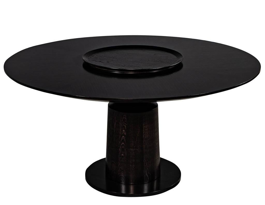 Round black oak dining table with bottle neck base. Encompassing minimalism and a blend of modern and transitional reference. With its graceful curves and sculptural physique, makes quite the impression. Ideal for intimate dining this distinct and