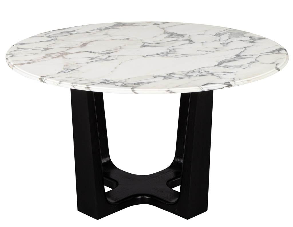 Custom modern round marble-top dining table. Custom round honed Calacatta Paonozzo stone top dining table with an ebonized modern base custom made by Carrocel.

Price includes complimentary scheduled curb side delivery service to the continental