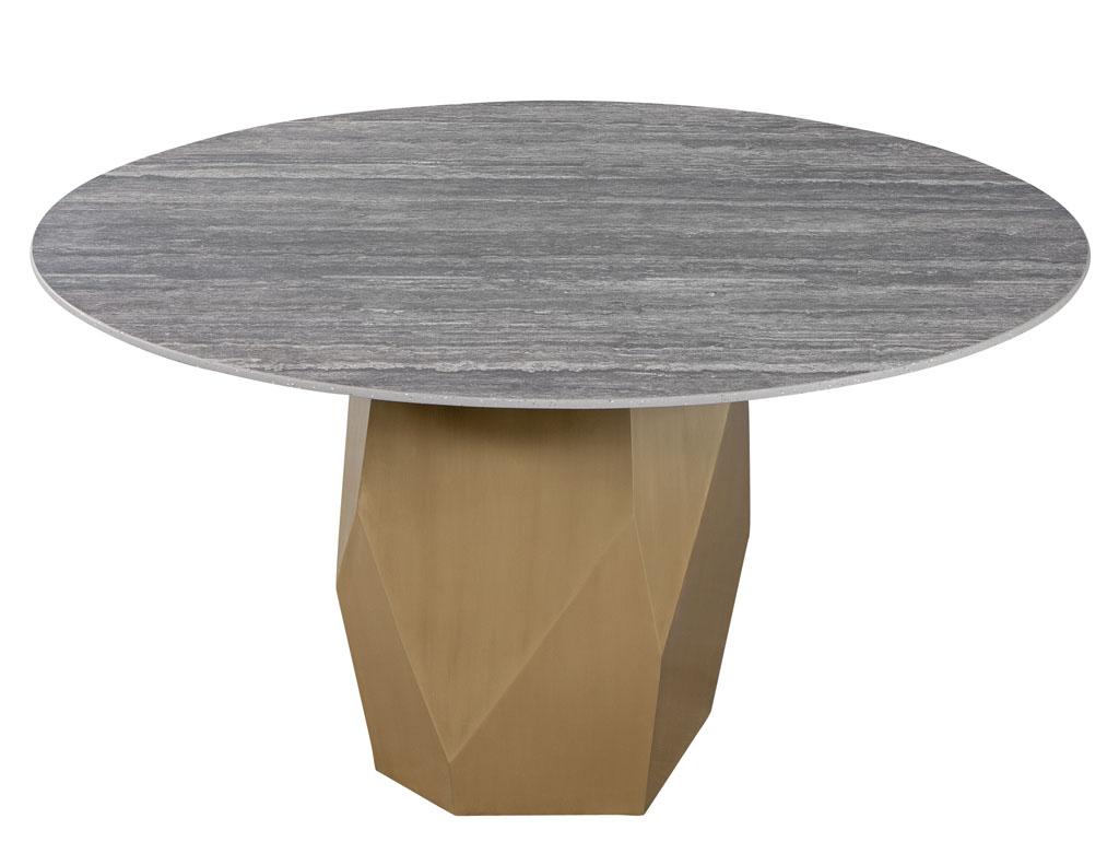 Custom modern round porcelain dining table with geometric brass base. Custom designed by the artisans at Carrocel with imported Italian honed travertino porcelain top. Completed with a uniquely designed geometric brass base to add a modern flare.