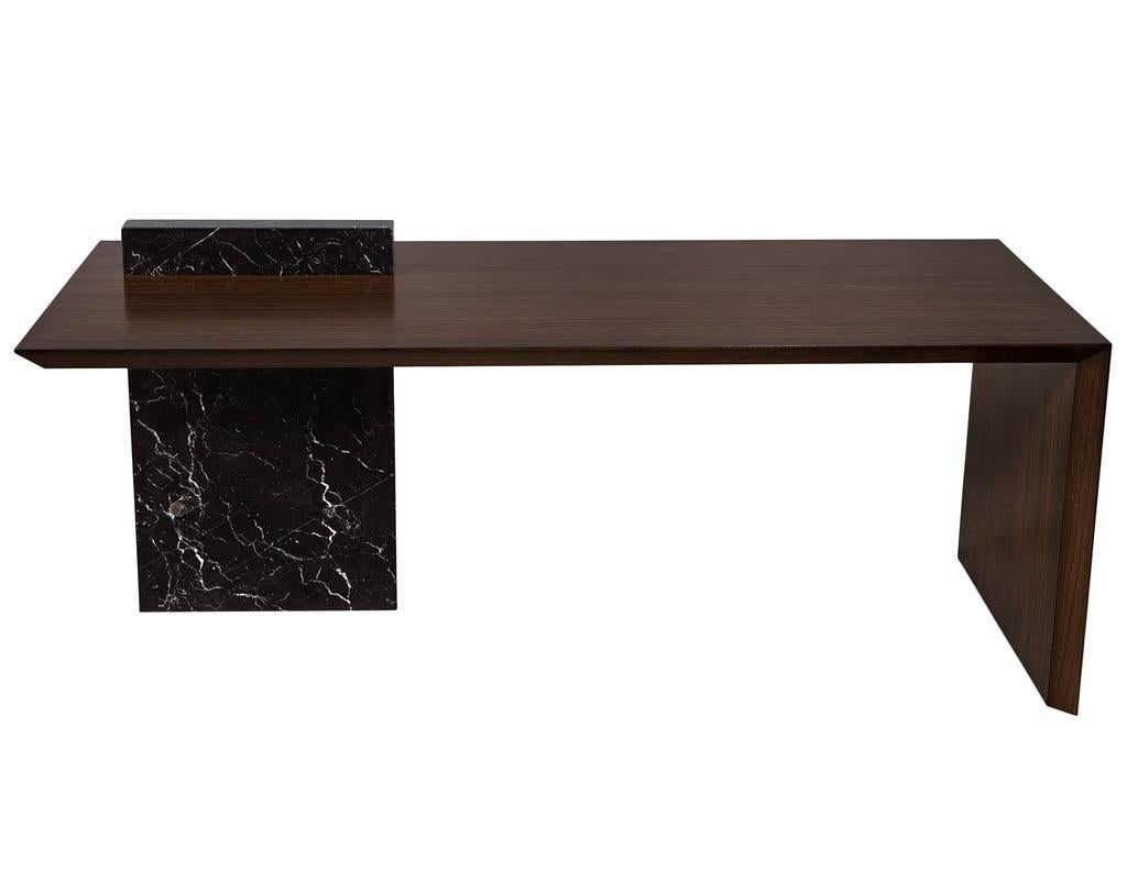 Custom modern waterfall desk with marble accent. Unique modern styling with rich walnut woods. Finished in a satin espresso color. Featuring beautiful nero marquino custom marble pedestal. Top marble height is 34