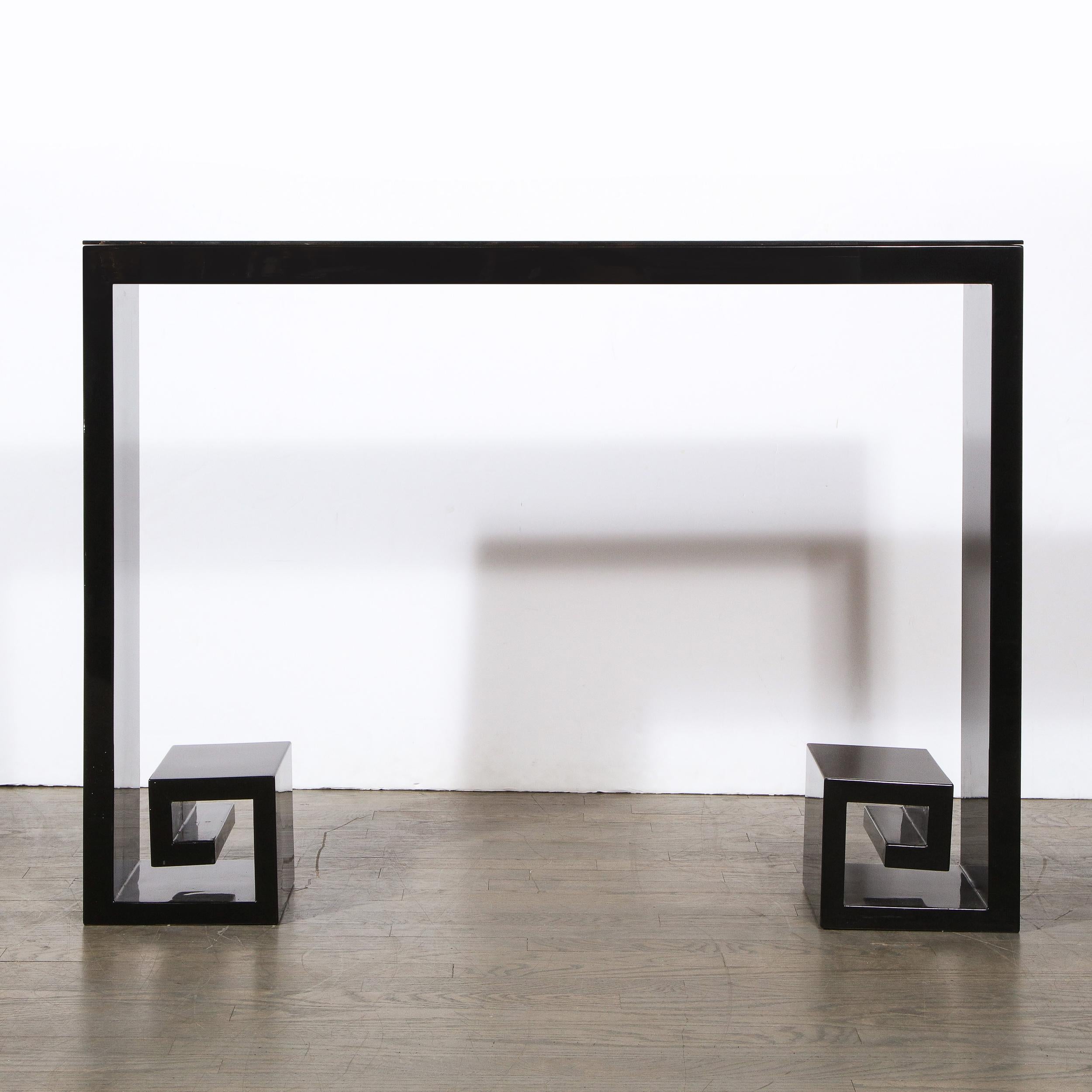 This stunning modernist black lacquer console was realized by artisans in New York state. It offers an open square form with stylized Greek key detailing at its base and a rectangular drawer in its centre. With its classically inspired form and