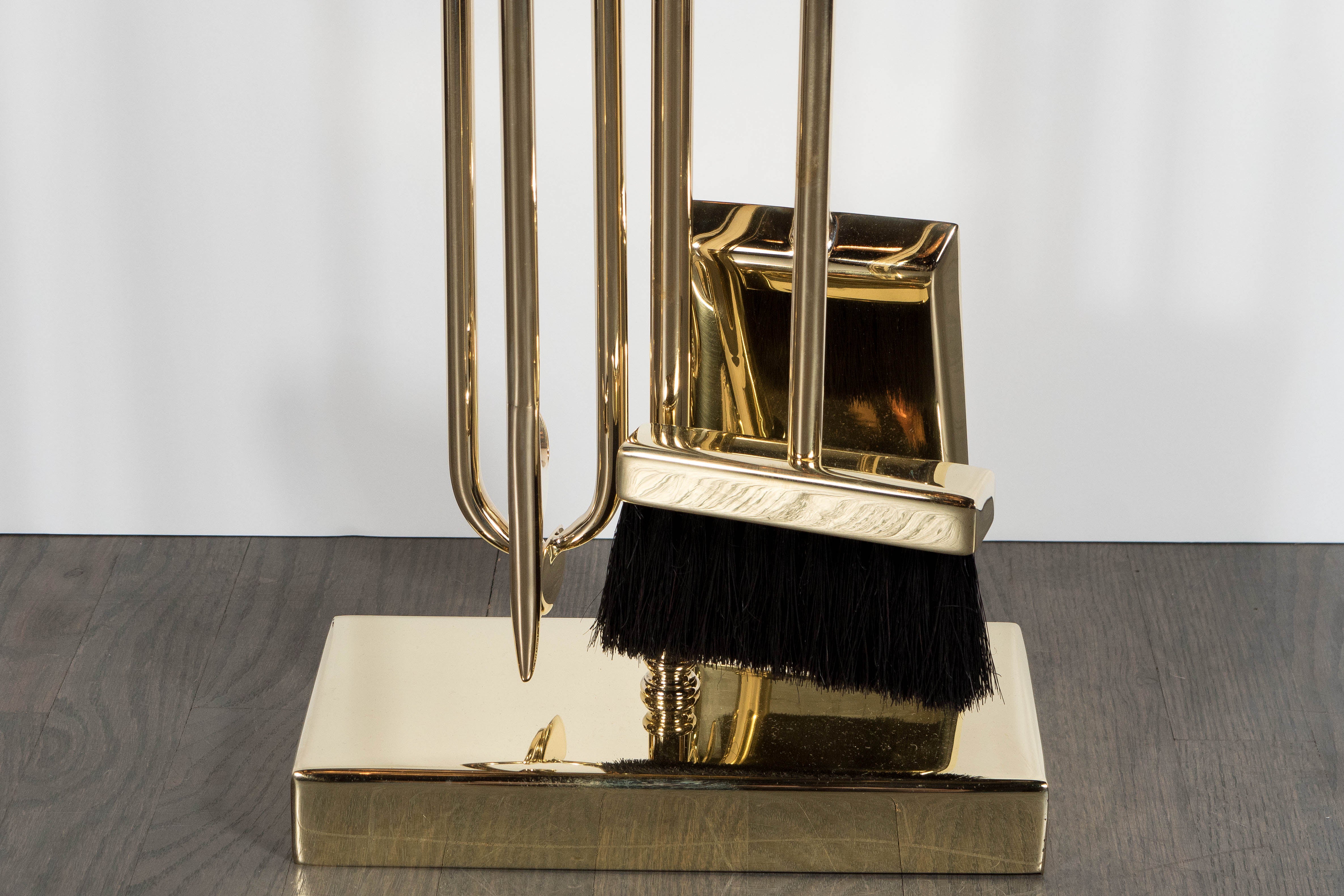 This refined and elegant modernist four-piece fire tool set was custom realized by artisans in New York State, exclusively for us. It features a shovel, brush, log holder and poker suspended from a notched rectangular top supported by a cylindrical