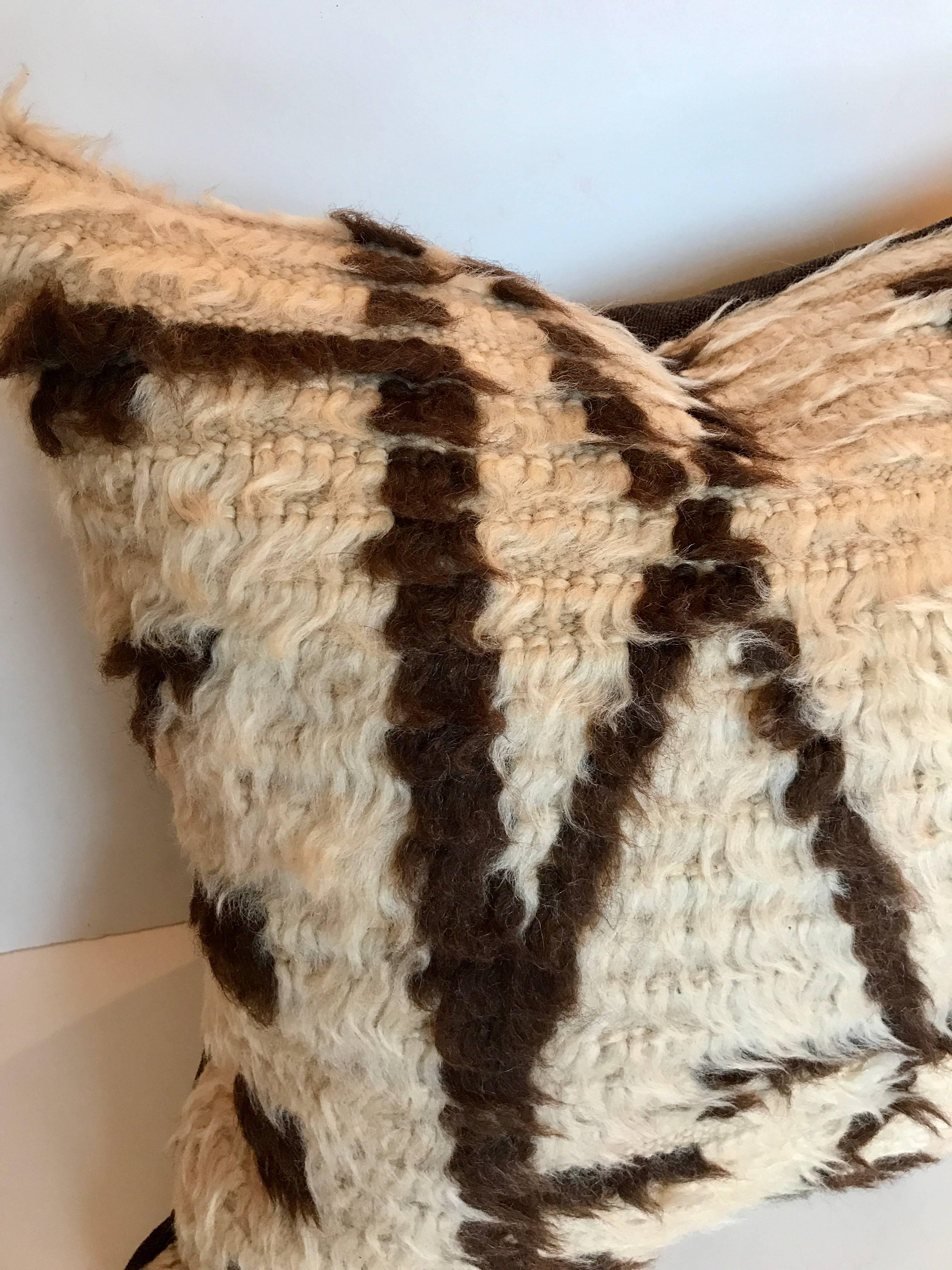 Custom pillow cut from a vintage hand loomed wool Moroccan Azilal rug made by the Berber tribes of the Atlas Mountains. Wool is soft and lustrous with natural colors in abstract tribal designs. Pillow is backed in a linen blend, filled with an