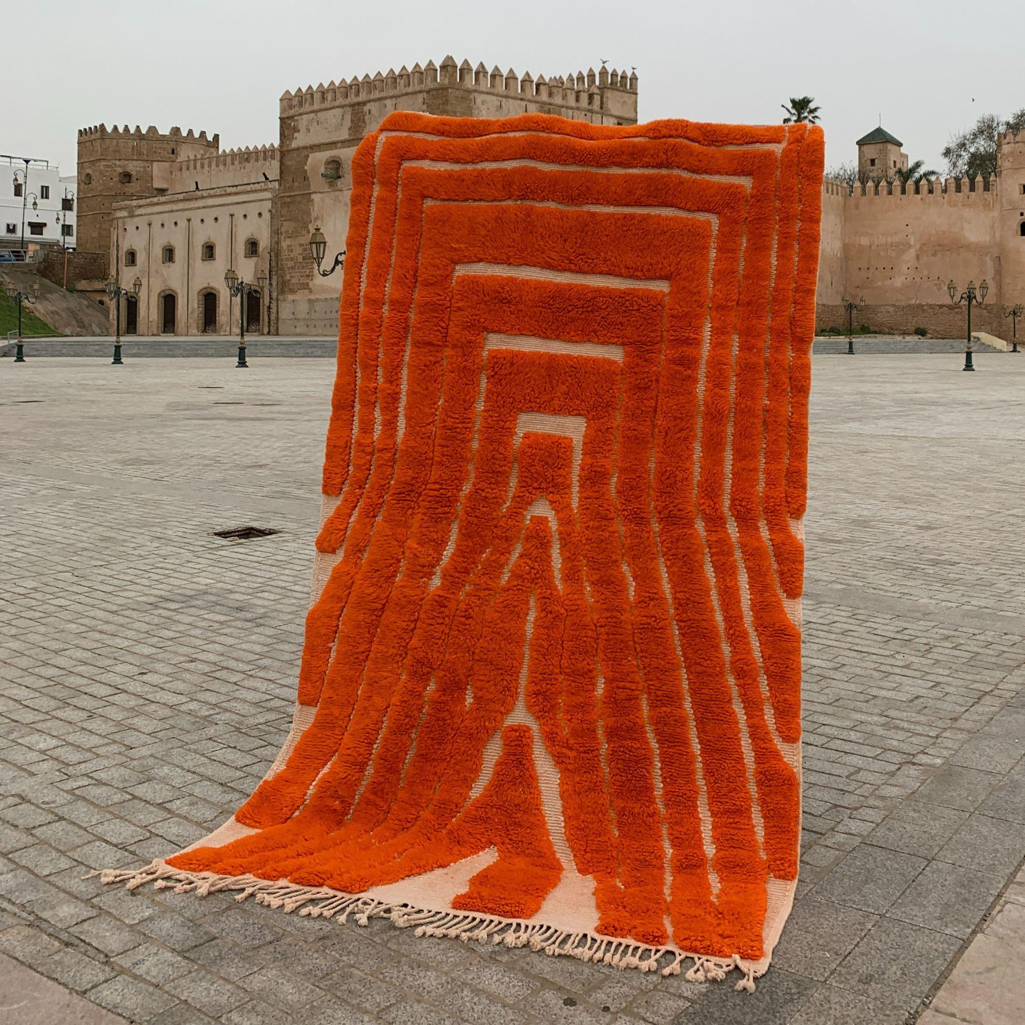 Voici le Sahara Symphony, un ajout exquis à notre collection de tapis marocains contemporains. Ce tapis orange vif présente un design texturé qui révèle subtilement sa base blanche, créant ainsi un attrait visuel saisissant. Tissé à la main par des