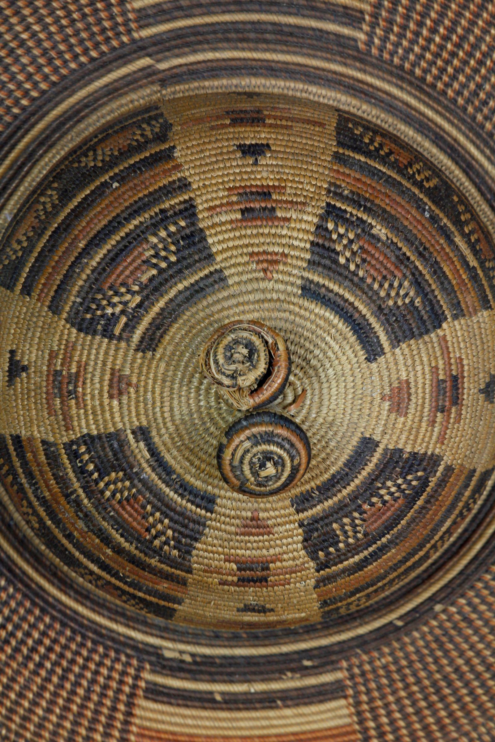 Ce chapeau en fibre d'herbe finement construit et décoré, provenant de la région du Kasaï en République démocratique du Congo, a été collecté dans les années 1930. Ce chapeau à larges bords a probablement été fabriqué pour le marché colonial précoce