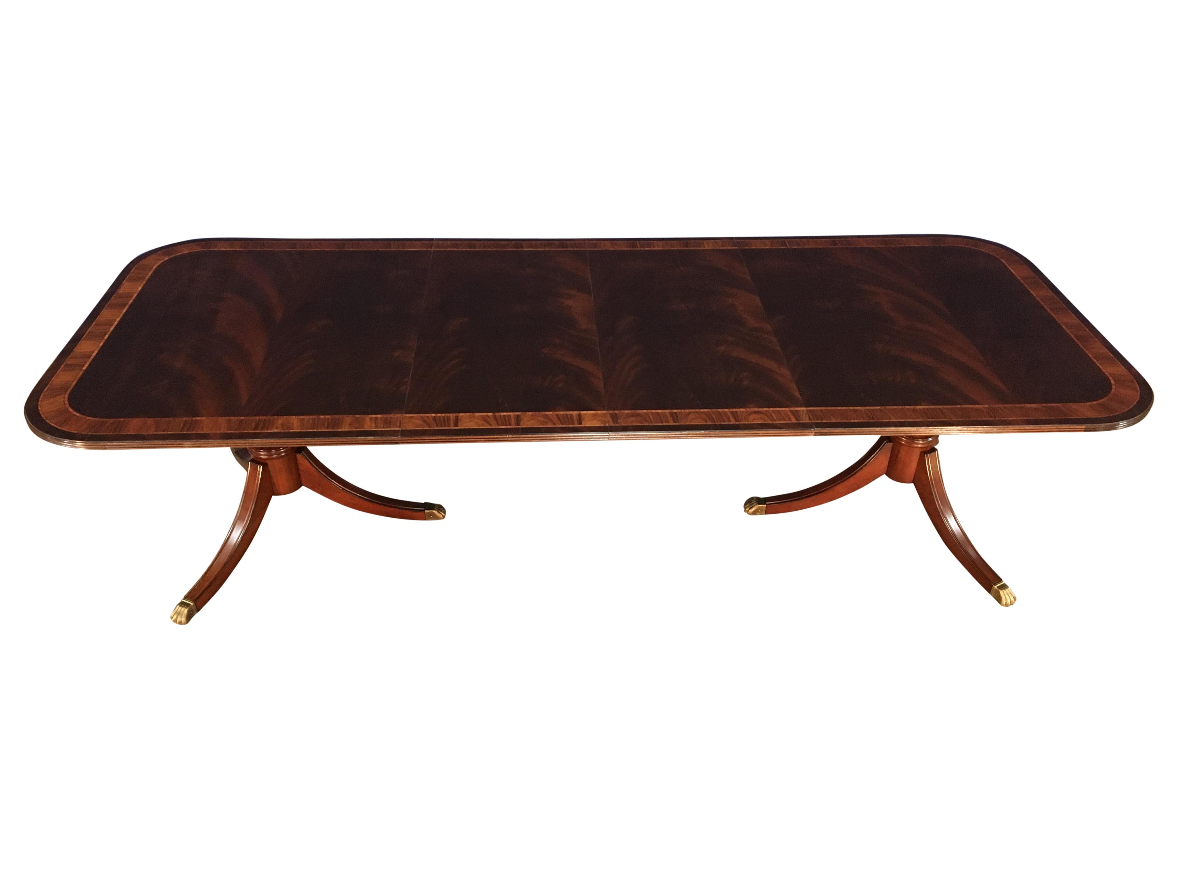 This is a made-to-order traditional mahogany dining table made in the Leighton Hall shop. It features a field of slip-matched swirly crotch mahogany from West Africa. It has a swirly crotch mahogany outer border with a Santos rosewood inner border.