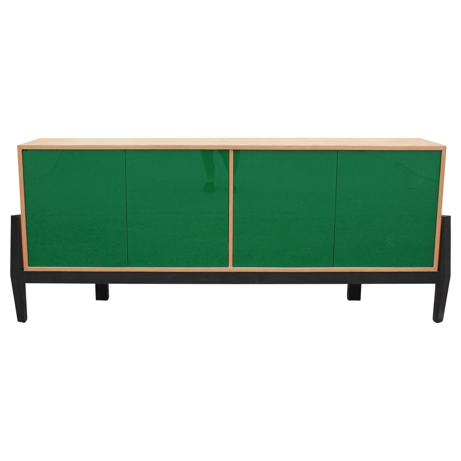 Natural Oak wood credenza or sideboard with four pop out doors. In the interior there are four storage shelves. The green lucite doors are reflective and shiny. The piece was designed by Reeves Design.

Current custom fabrication time 6-8 weeks. All