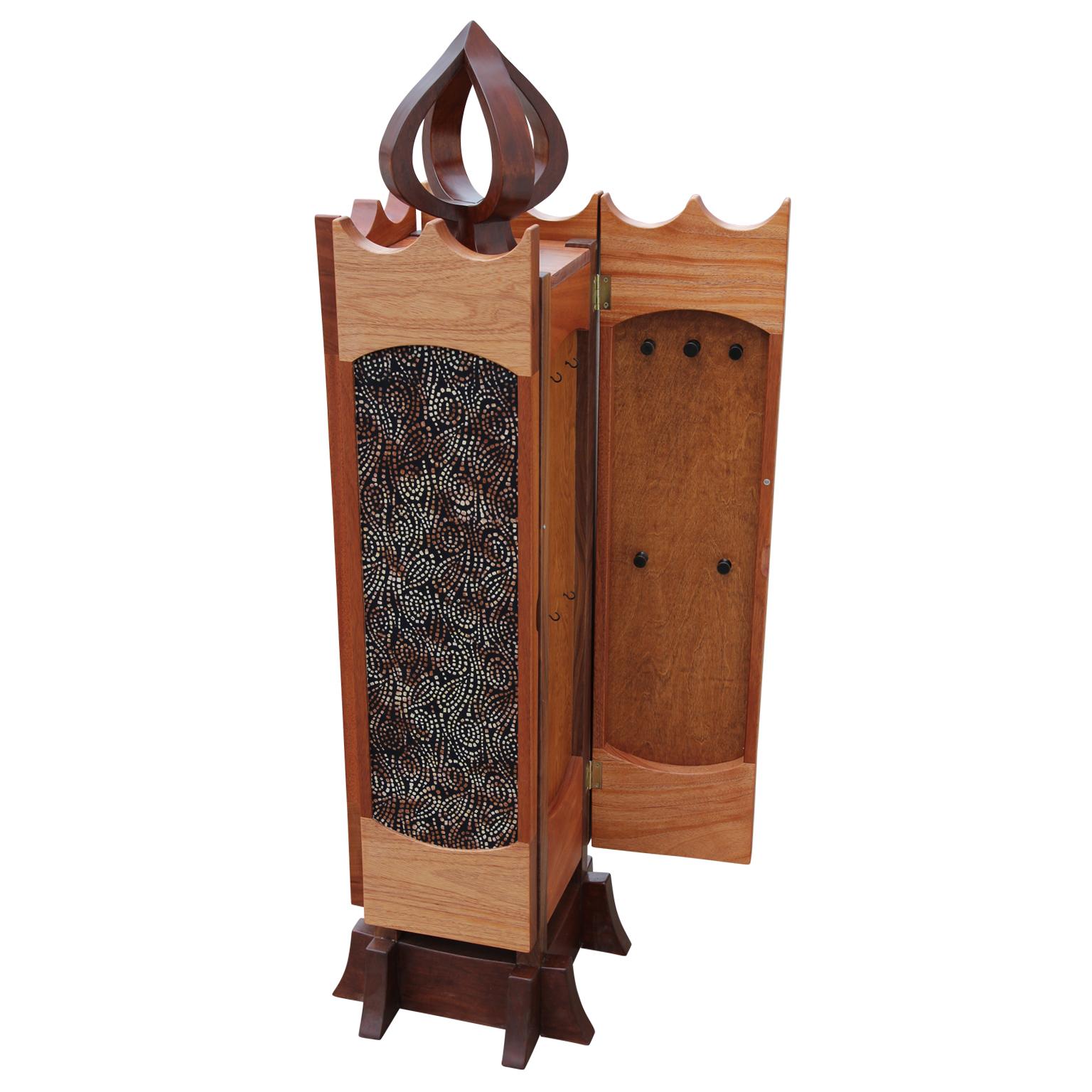 This beautiful piece by Norm Stoeker opens on three sides to reveal a variety of jewelry storage. The right and left sides open to have multiple pegs for hanging longer pieces. The front panel opens to reveal a tower of 9 drawers and a pullout /