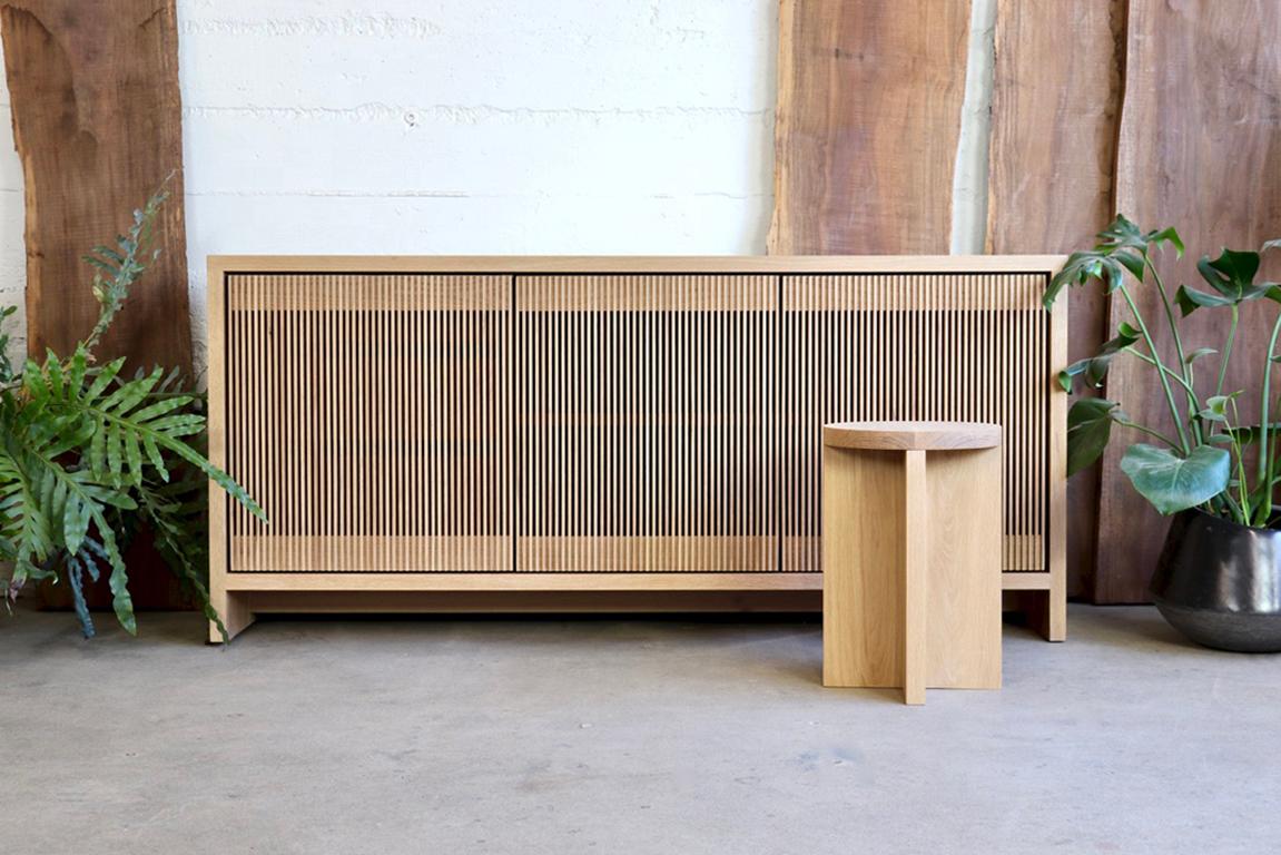 This credenza is custom to be built from (2) pieces so it can be assembled in the field with simple tools (allen wrench). 

Solid wood credenza / sideboard with slatted screen doors in white oak built by Material in Portland, Oregon. The clean