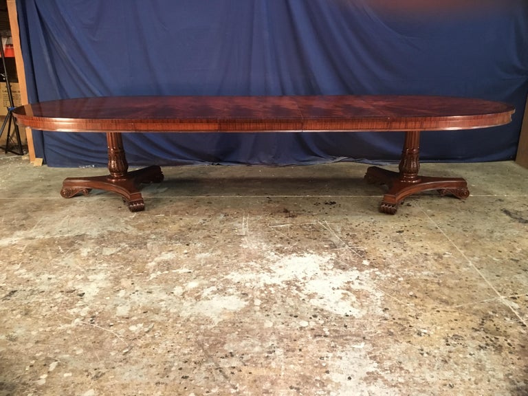 This is made-to-order oval traditional mahogany dining table made in the Leighton Hall shop. It features a radial cut field of West African swirly crotch mahogany and two borders of Santos rosewood and crotch mahogany. The top has a hand rubbed and