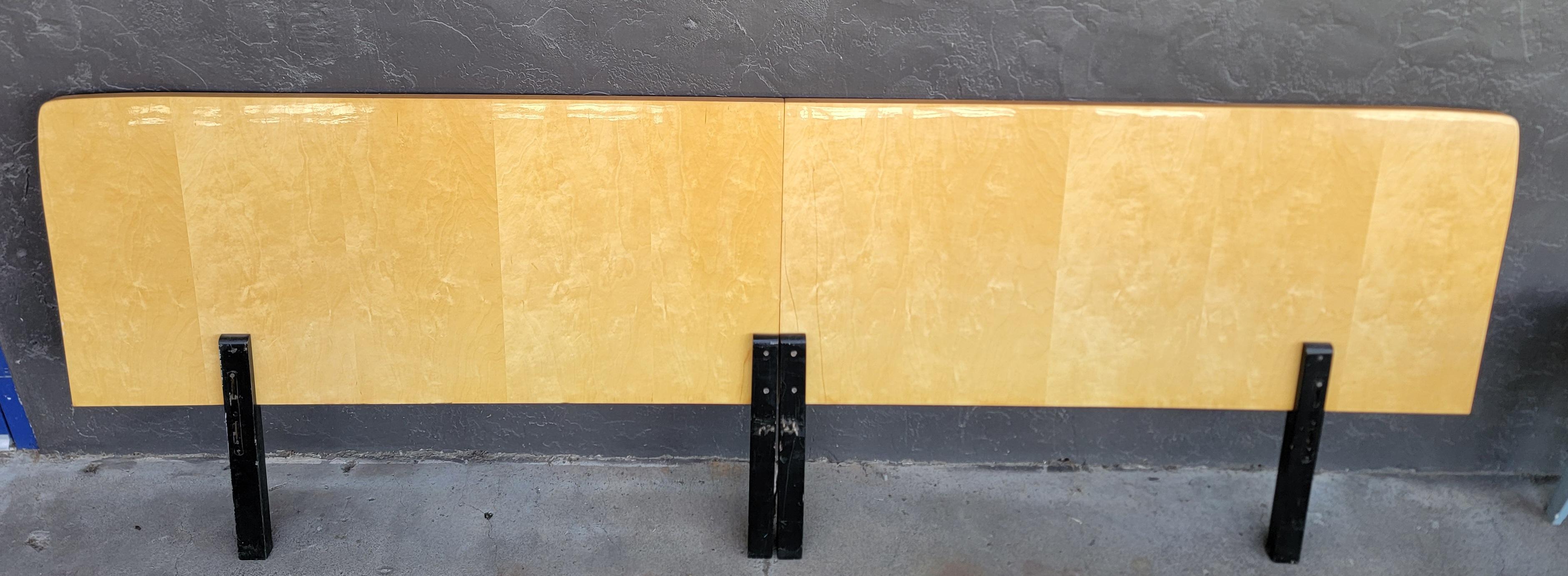 An over-sized 2 piece headboard made with lacquered maple. Larger than a king size. Measures 104 inches wide. High gloss finish with painted black legs. Original finish. Each side could fit a double bed headboard as the each measure 52 inches wide.