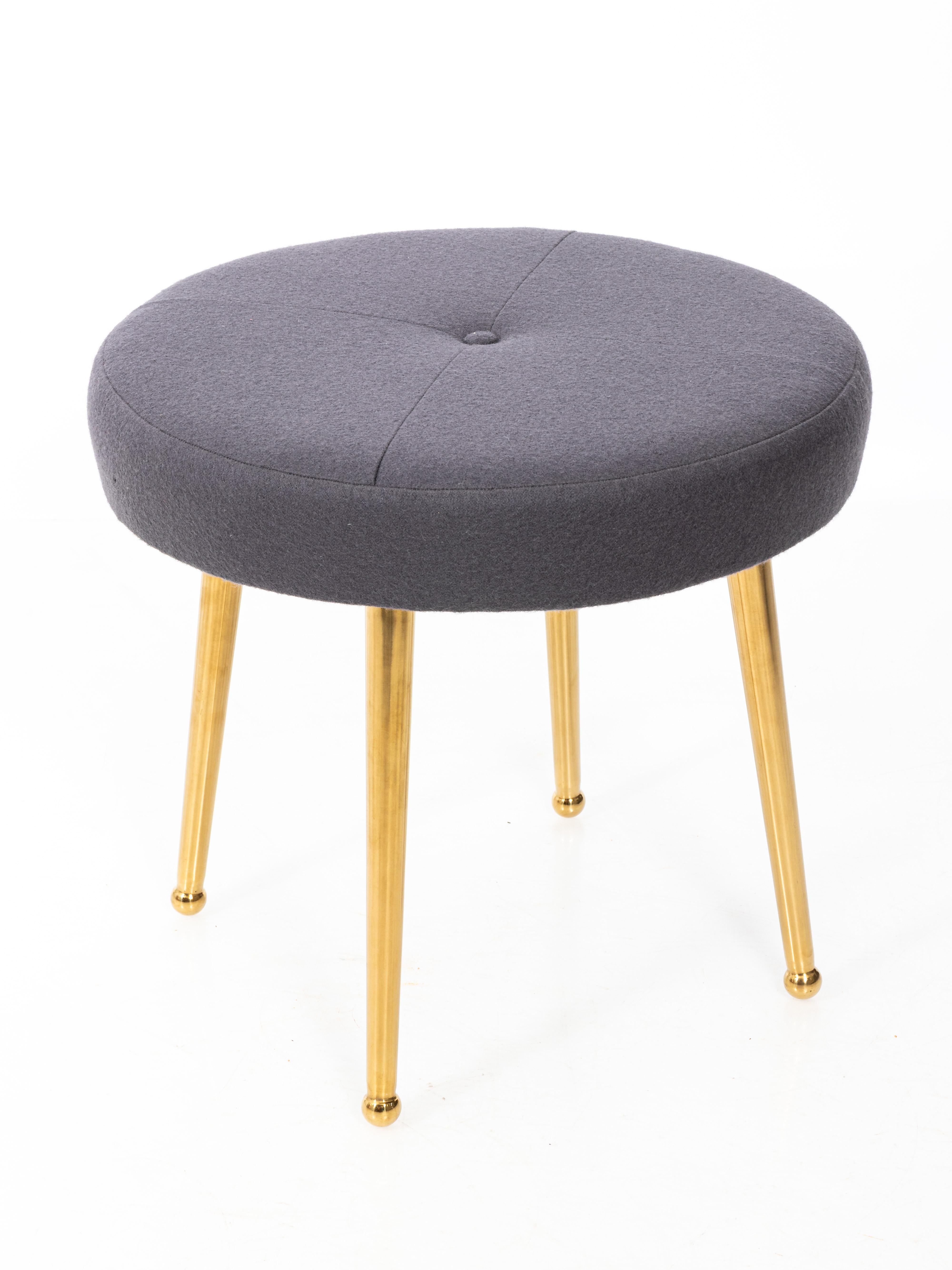 Pair of custom midcentury style round stools. Shown with brass legs and wool tops with button and quadrant seaming. Available COM /COL. Can be professionally packed and shipped through UPS.