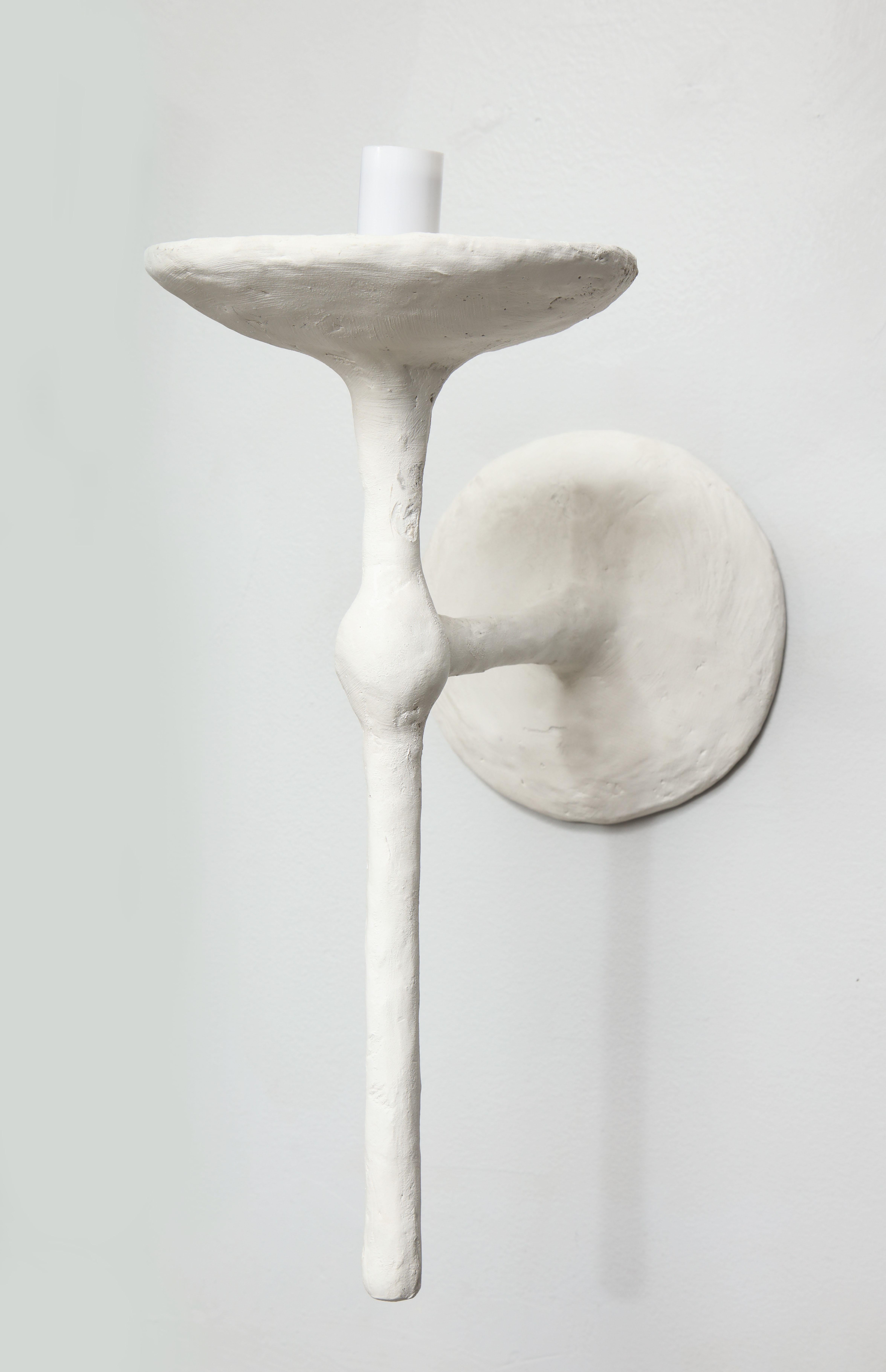 Paire personnalisée d'appliques en plâtre à un bras, à la manière de Giacometti, 
21ème siècle. Nous avons actuellement une paire en stock.
Veuillez noter que les appliques fonctionnent avec des ampoules candélabres E-12, 40 watts.
Le délai de