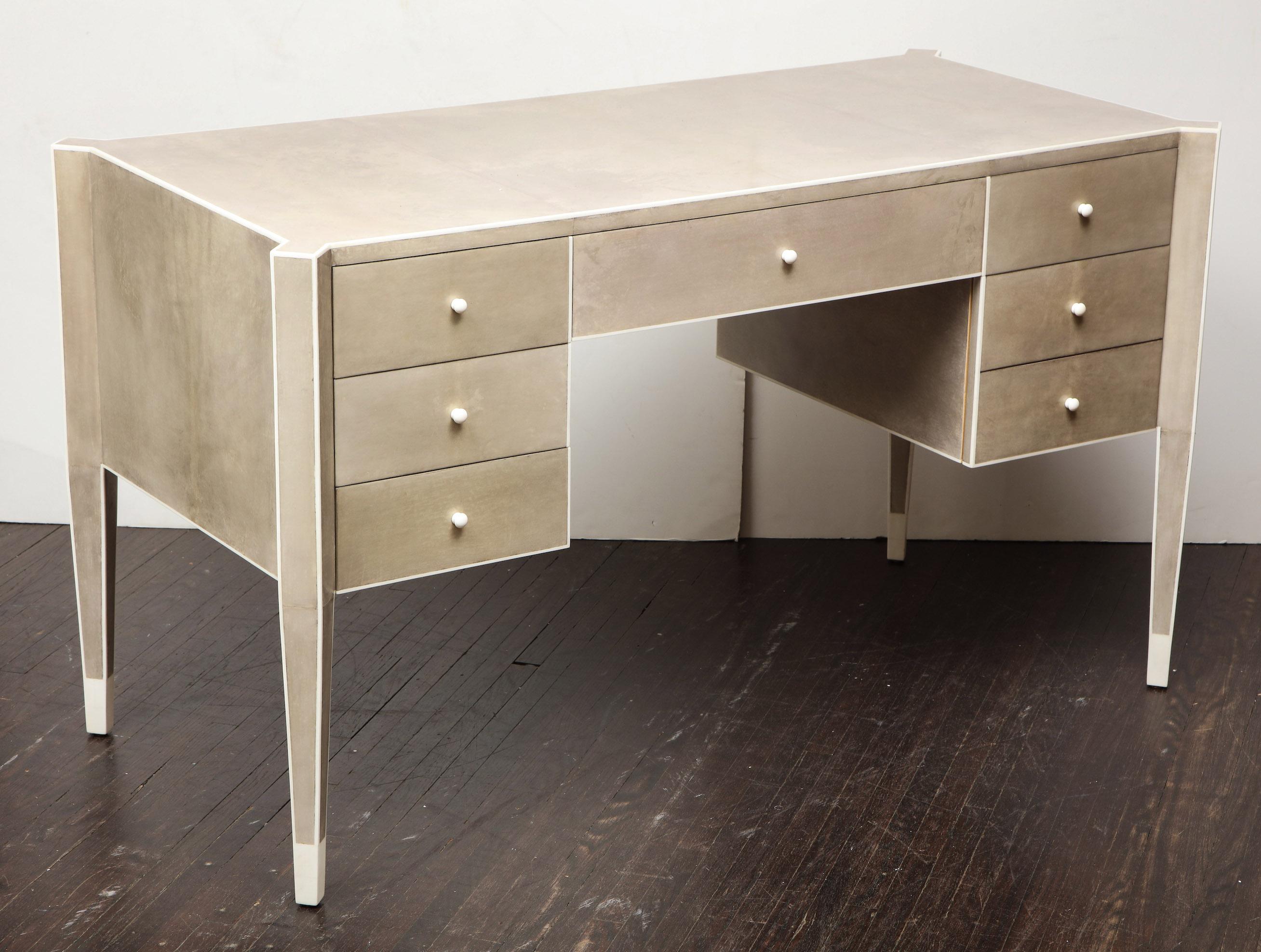 Made to order, custom desk covered in parchment with trim detail and pulls in bone. The desk shown is in mushroom grey (custom color). Custom dimensions available.