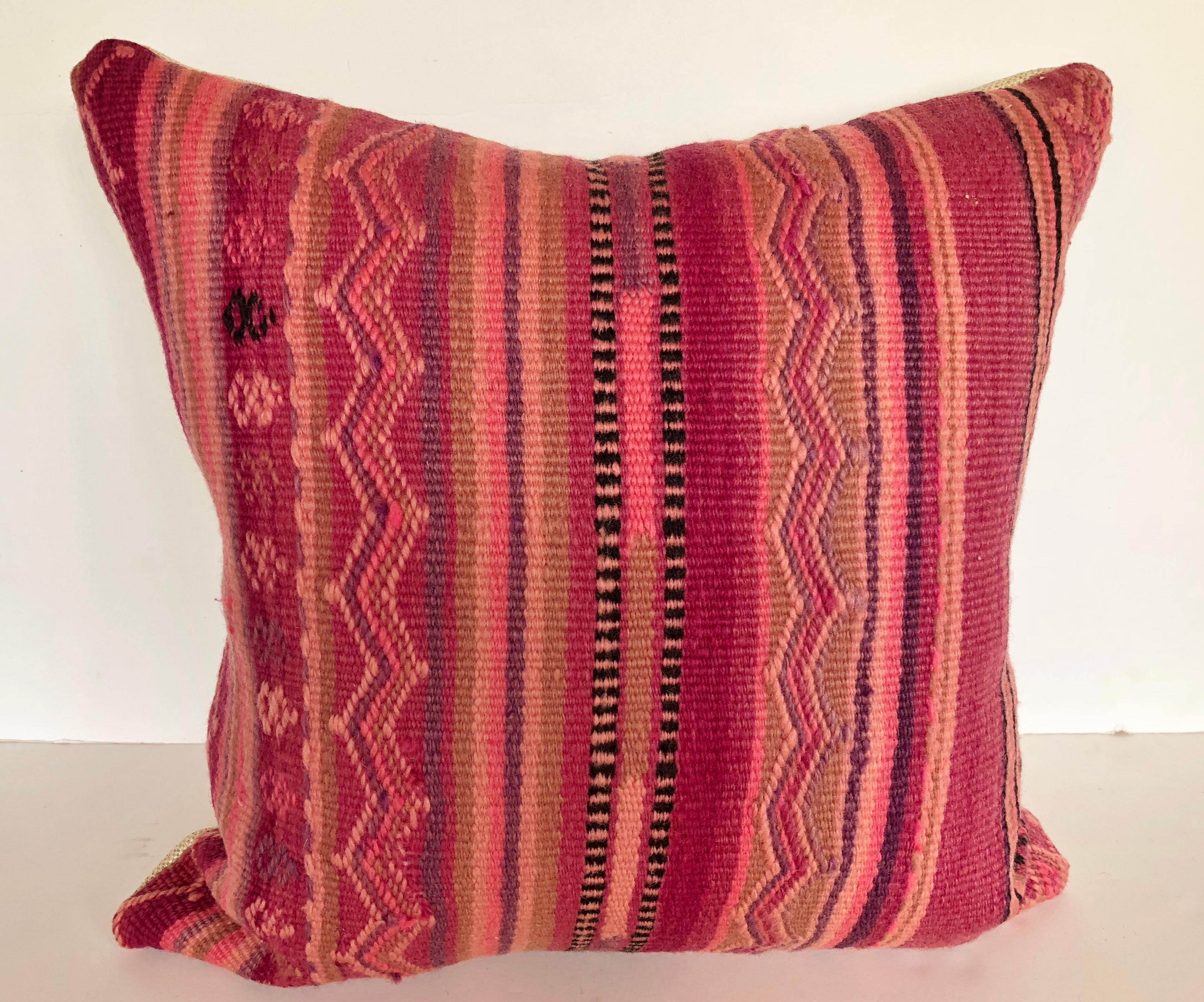 Custom pillow cut from a vintage hand loomed wool Moroccan rug made by the Berber tribes of the Atlas Mountains. Wool is soft and lustrous with natural dyes. The flat-weave stripes are embellished with embroidered tribal designs. Pillow is backed in