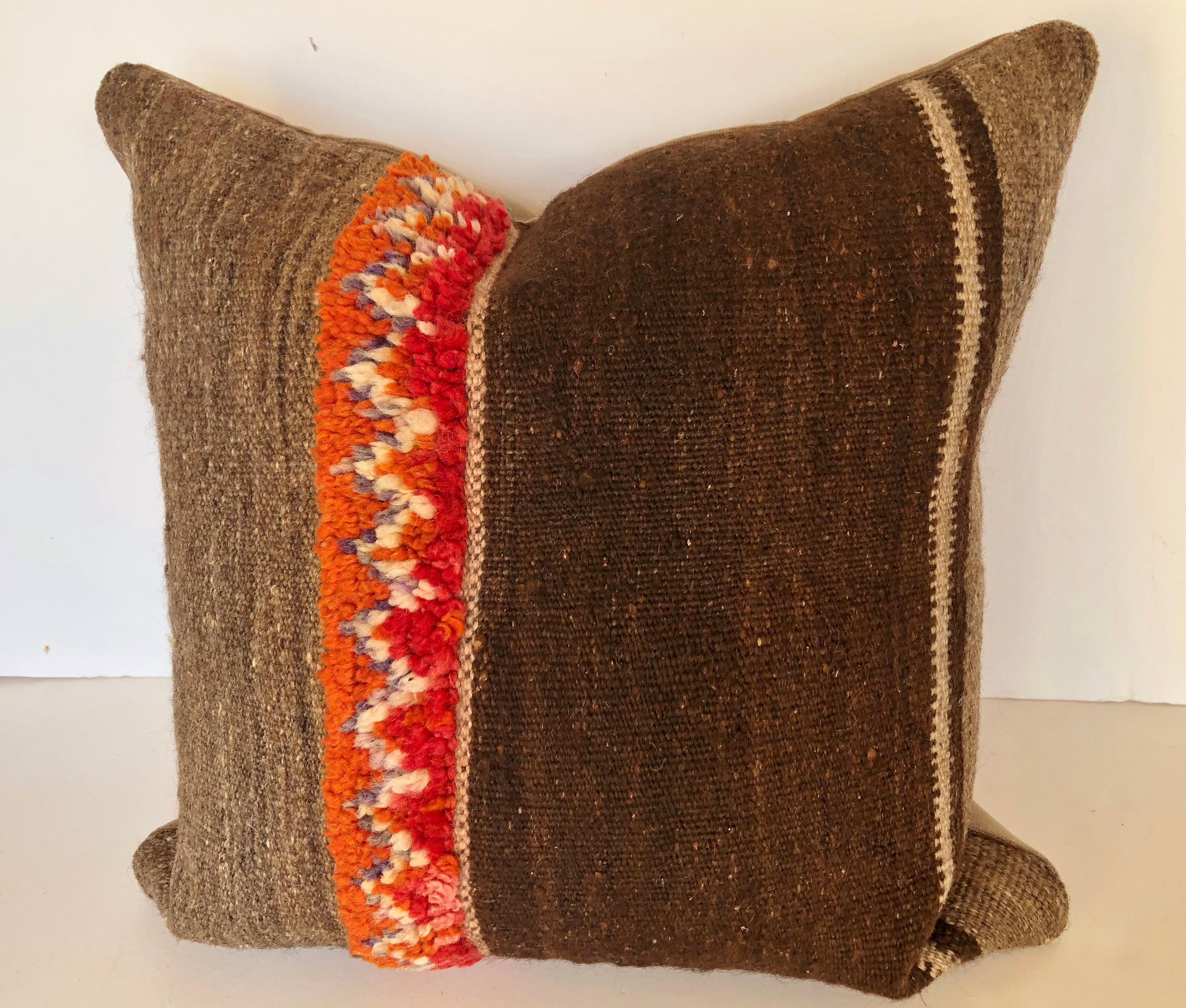 Custom pillow cut from a vintage hand loomed wool Moroccan Berber rug from the Atlas Mountains. Wool stripes are embellished with colorful tufted bands. Pillow is backed in velvet, filled with an insert of 50/50 down and feathers and handsewn