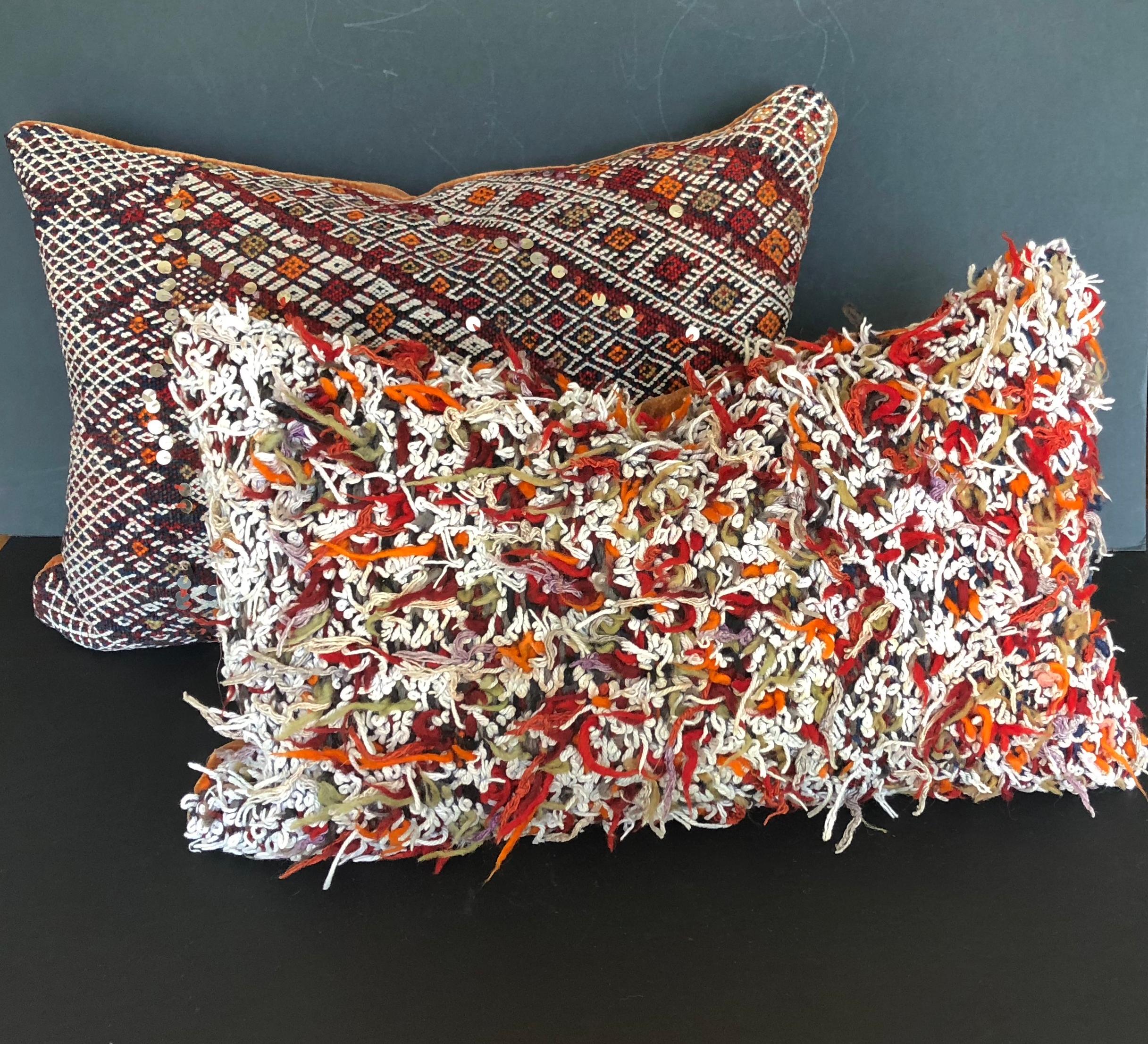 Custom pillow cut from a vintage hand loomed wool Moroccan Berber rug from the Atlas Mountains. The pillow is cut from the reverse side of the rug where all of the wool was left uncut after the weaving process. Pillow is backed in deep paprika