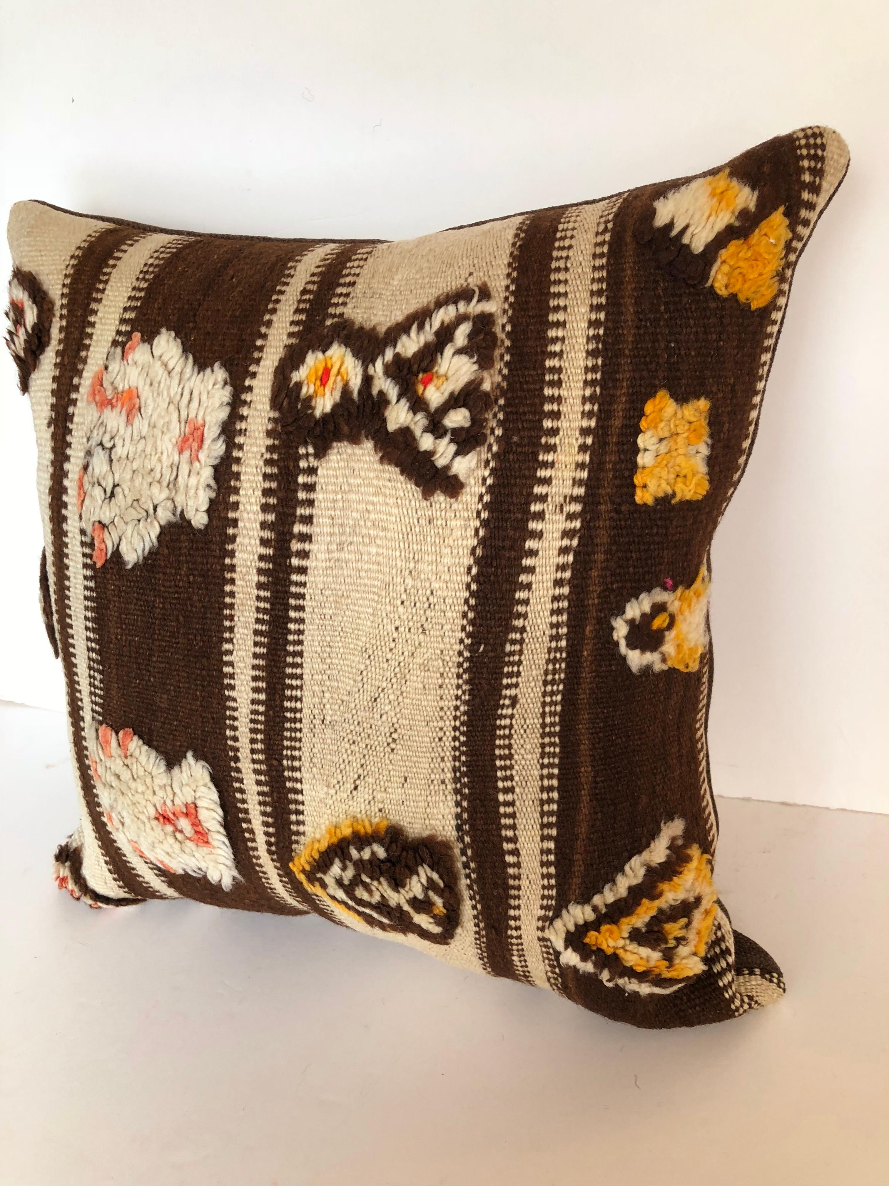Custom pillow cut from a vintage hand loomed wool Moroccan Berber rug from the Atlas Mountains. Wool is soft and lustrous with natural dyes and tufted tribal designs. Pillows is backed in dark brown linen blend, filled with an insert of 50/50 down