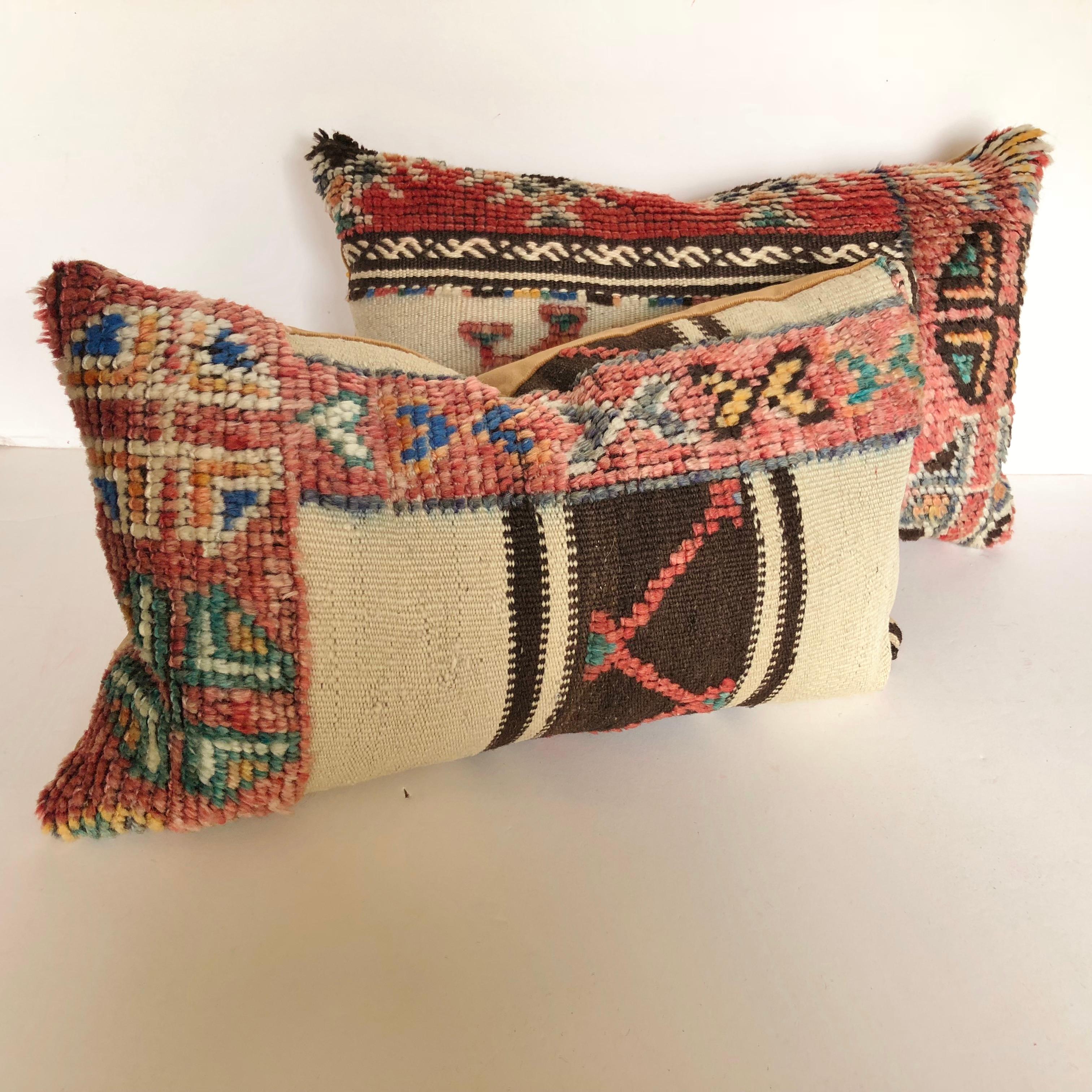 Custom pillow cut from a vintage hand loomed wool Moroccan Ourika Berber rug from the Atlas Mountains. Wool is soft and lustrous with all natural dyes. Flat weave stripes are embellished with tufted tribal designs. Pillow is backed in velvet, filled