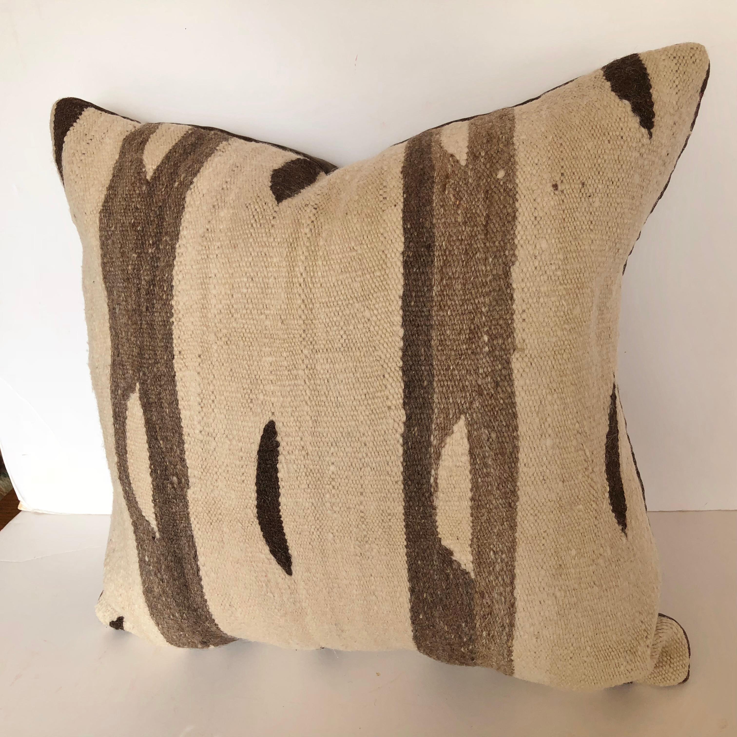 Custom pillow cut from a vintage hand loomed wool Moroccan rug made by the Berber tribes in the Ourika Valley of the Upper Atlas Mountains. The wool is soft and lustrous with all natural color. The pillow is backed in velvet, filled with an insert
