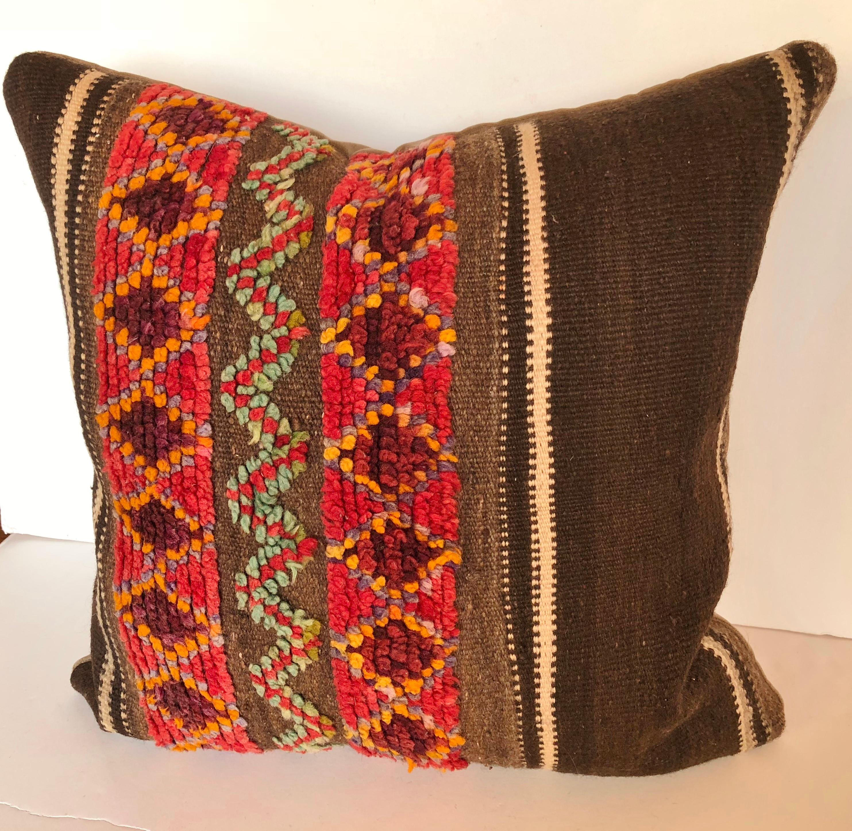 Custom pillow cut from a vintage hand loomed wool Moroccan Berber rug from the Atlas Mountains. Wool stripes are soft and lustrous with a colorful tufted tribal design. Pillow is backed in velvet, filled with an insert of 50/50 down and feathers and