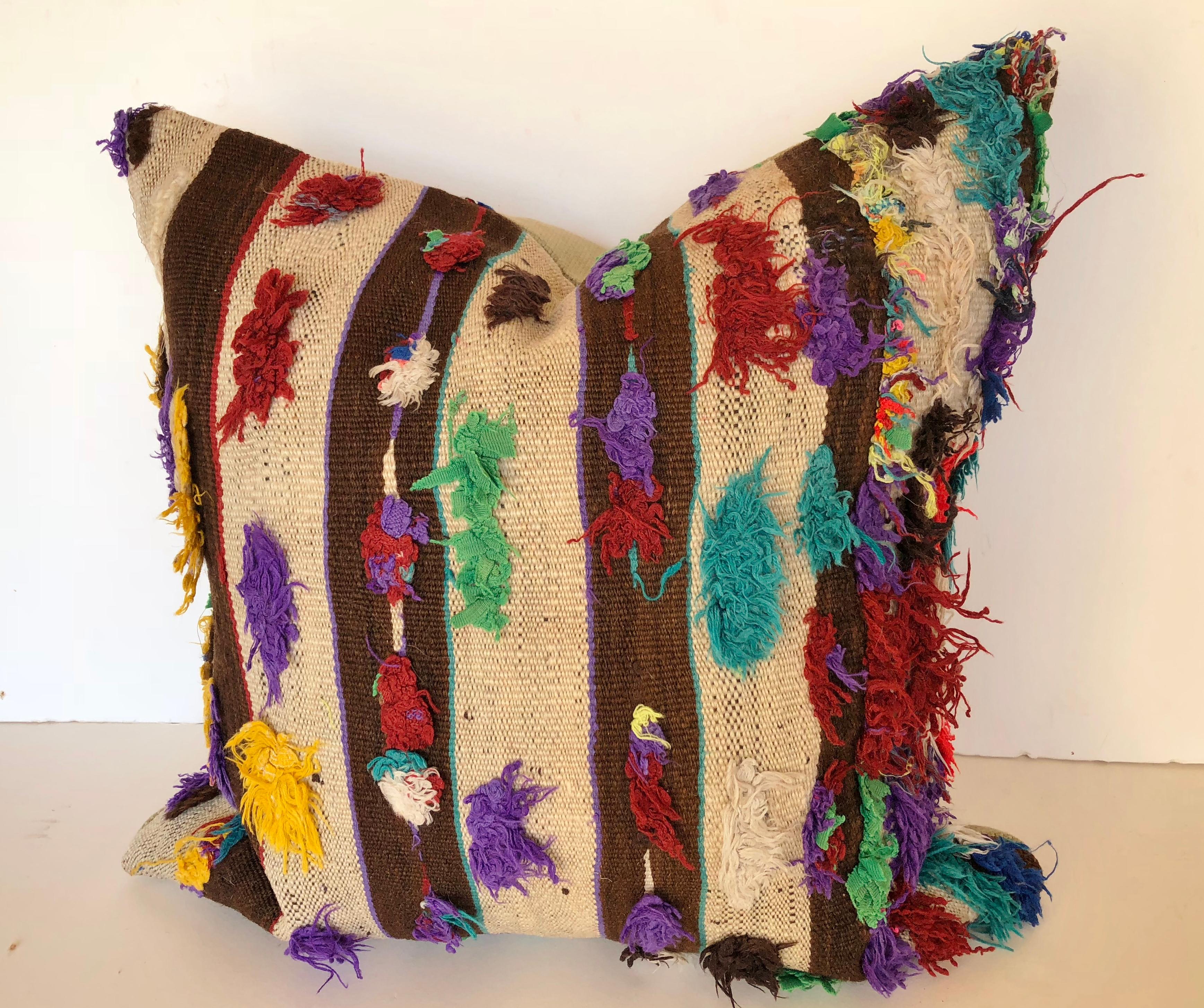 Custom pillow cut from a vintage hand loomed wool Moroccan rug, made by the Berber tribes of the Atlas Mountains. Wool stripes are soft and lustrous with brightly colored tufting. Pillow is backed in a linen blend, filled with an insert of 50/50