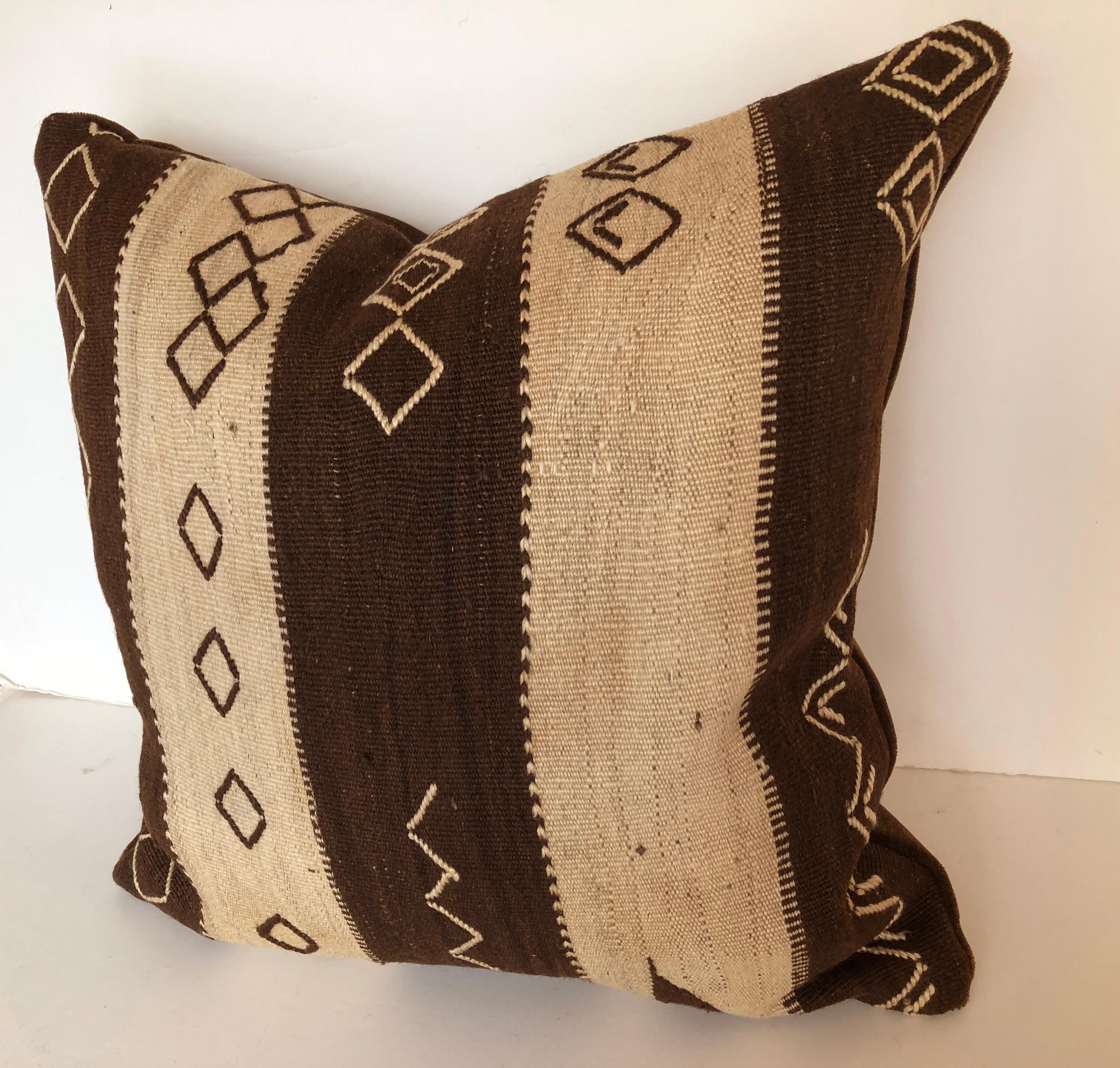 Custom pillow cut from a vintage hand loomed wool Moroccan rug from the Ourika Valley, Upper Atlas Mountains. Wool is soft and lustrous with all natural color, embroidered with tribal designs. Pillow is backed in dark brown mohair, filled with an