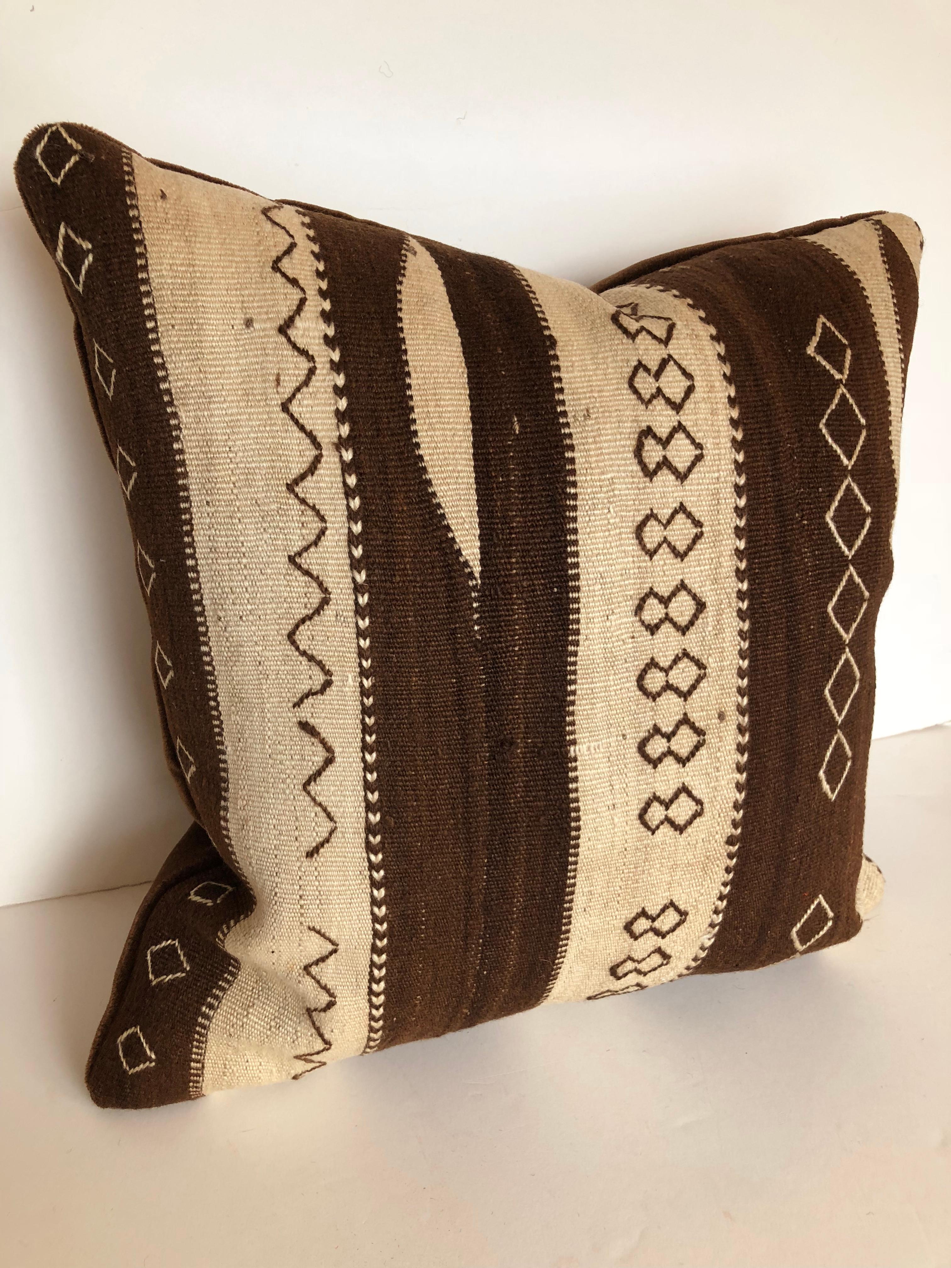 Custom pillow cut from a vintage hand-loomed wool Moroccan rug from the Ourika Valley in the high Atlas Mountains. Wool is soft with all natural color and embroidered tribal designs.
Pillows are backed in dark brown mohair, filled with an insert of